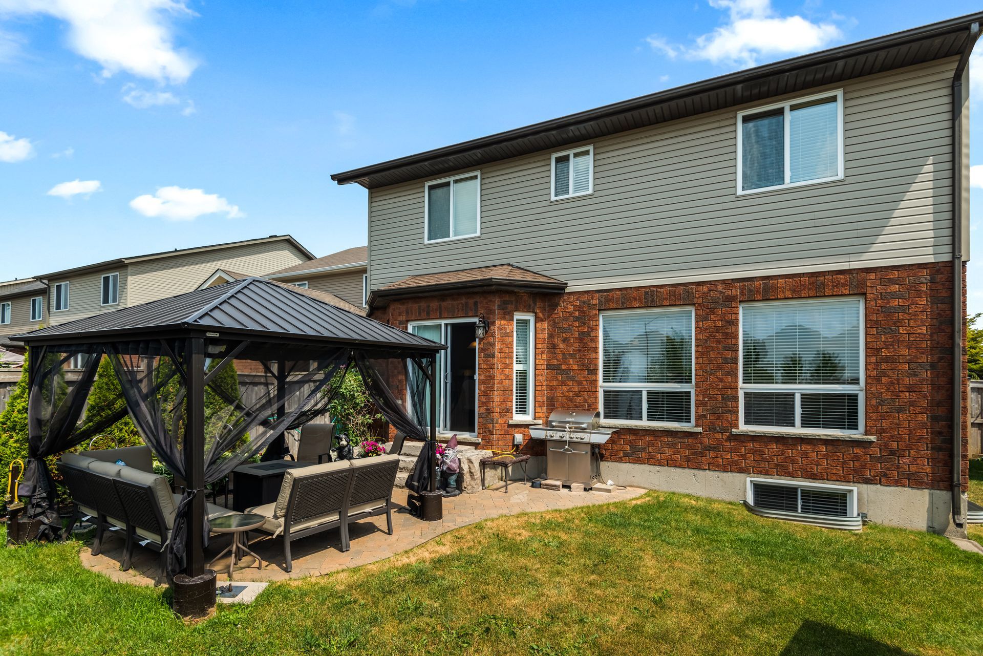 There is a gazebo in the backyard of a house.