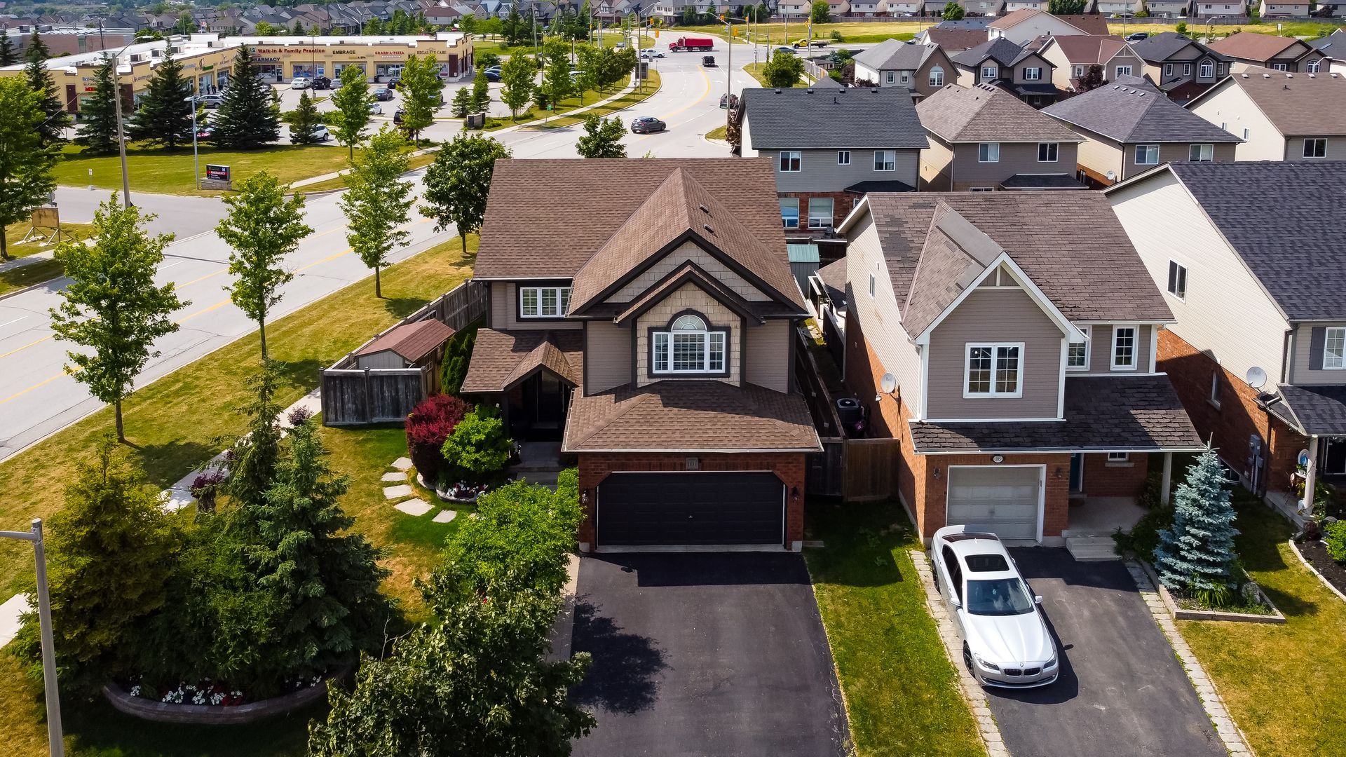 An aerial view of a residential area with a car parked in front of a house.