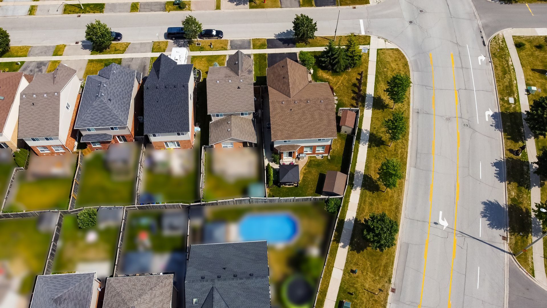 An aerial view of a residential area with houses and a pool.