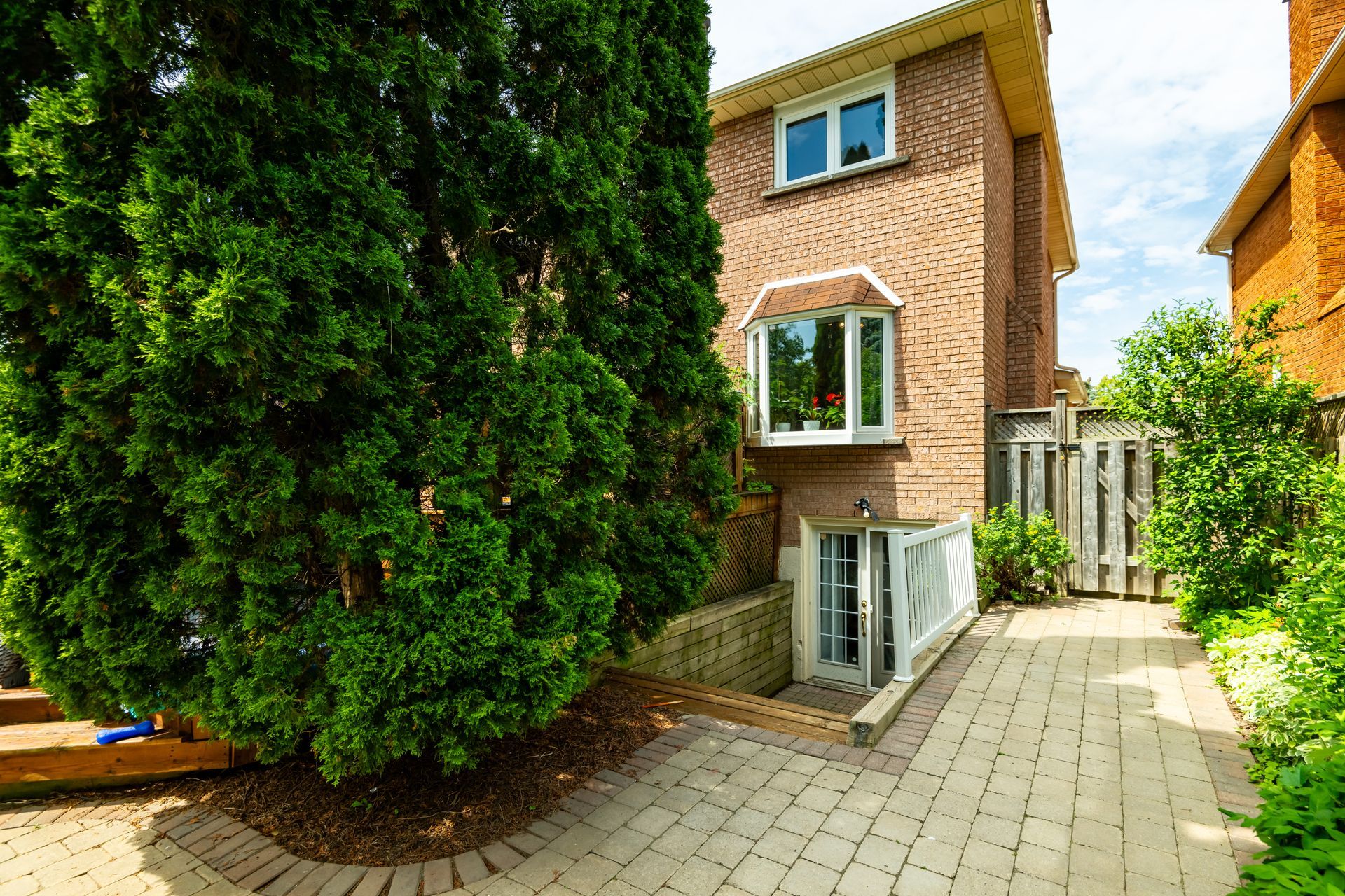 A brick house with a large tree in front of it.