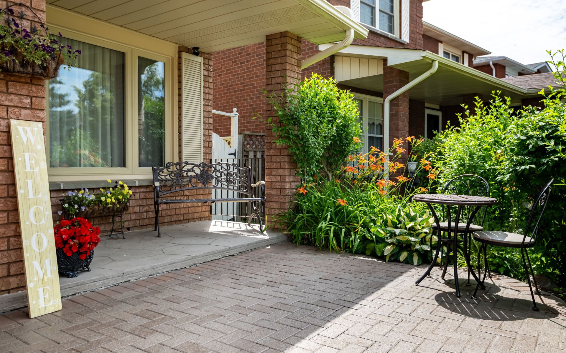 A patio with a table and chairs in front of a brick house.