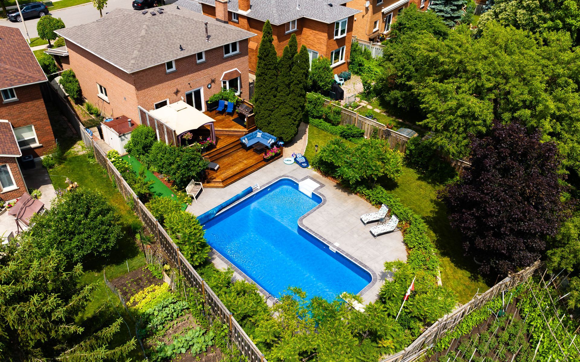 An aerial view of a house with a large swimming pool in the backyard.