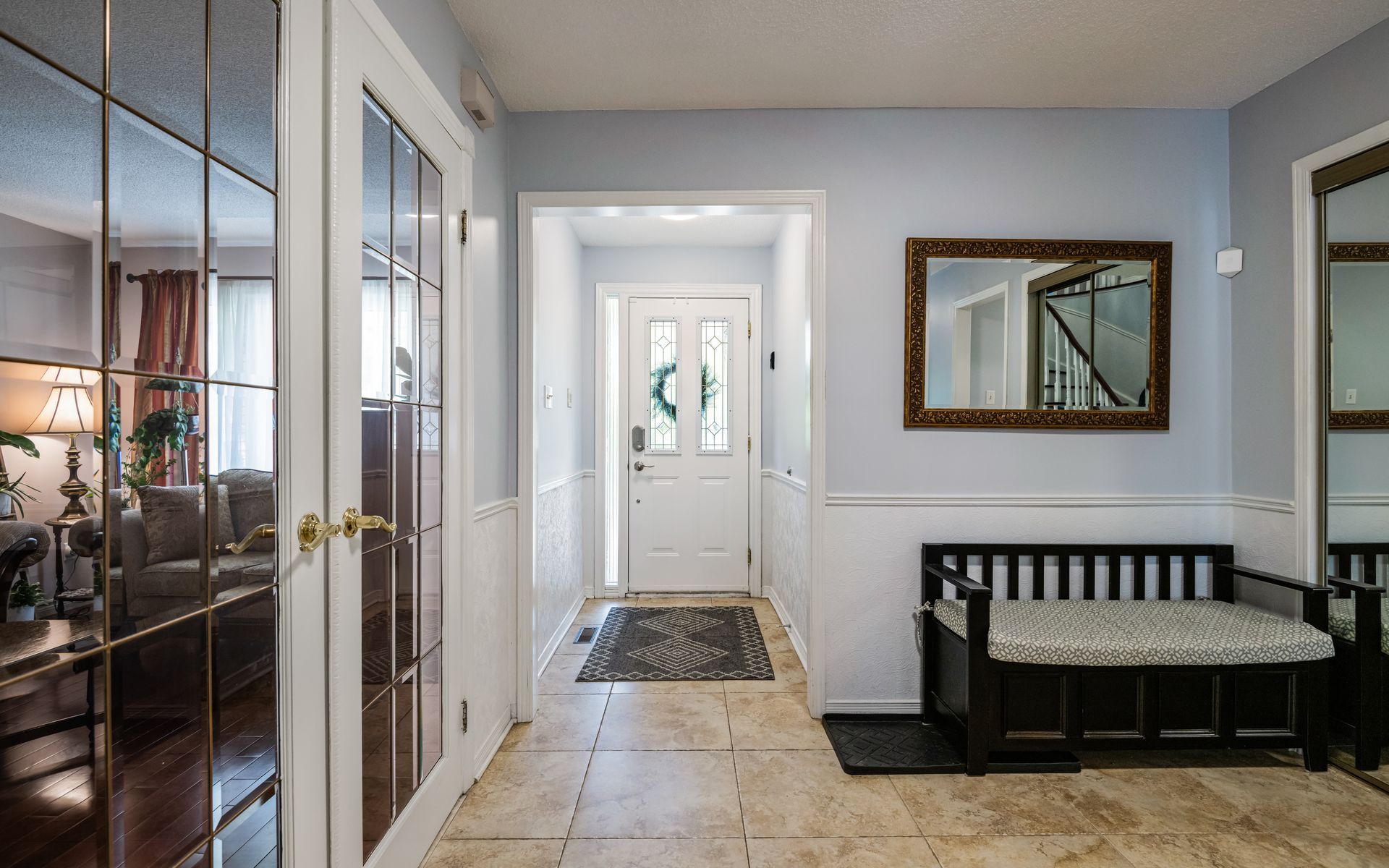 a hallway in a house with a bench and a mirror .
