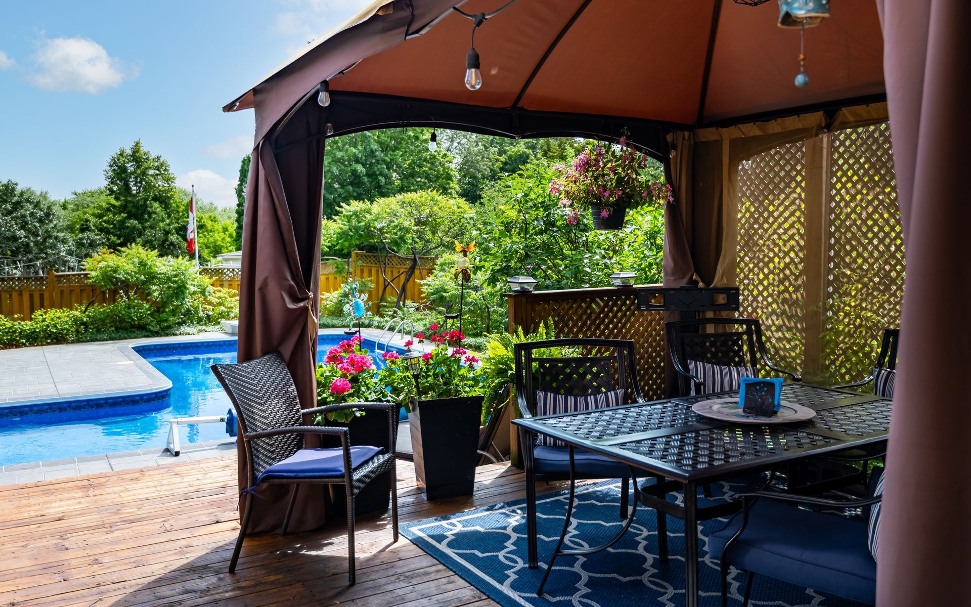 a gazebo with a table and chairs in front of a pool .