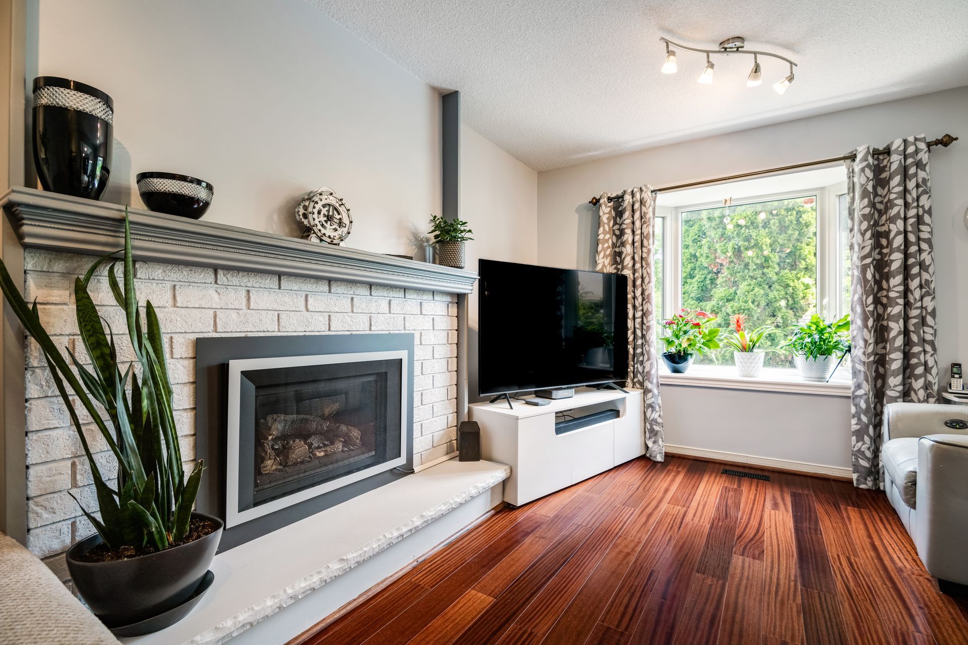 A living room with a fireplace and a flat screen tv.