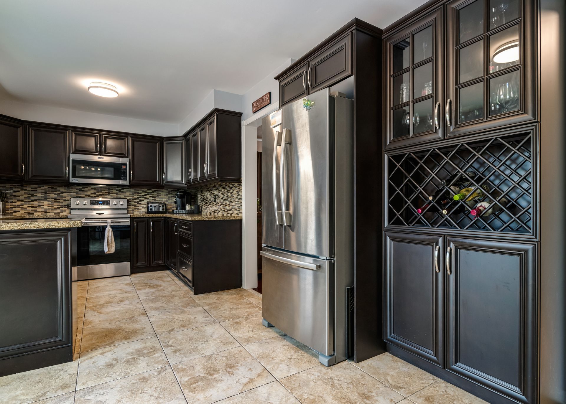 A kitchen with stainless steel appliances and black cabinets.