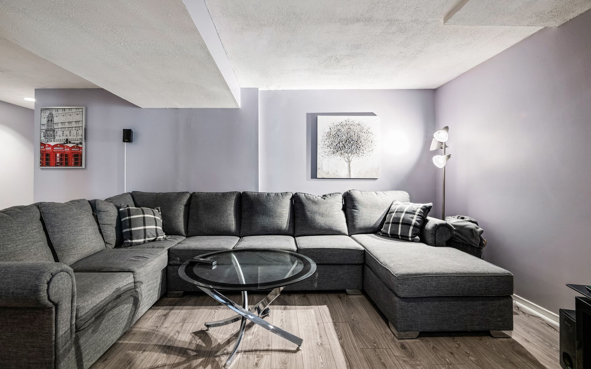 A living room with a large sectional couch and a glass coffee table.