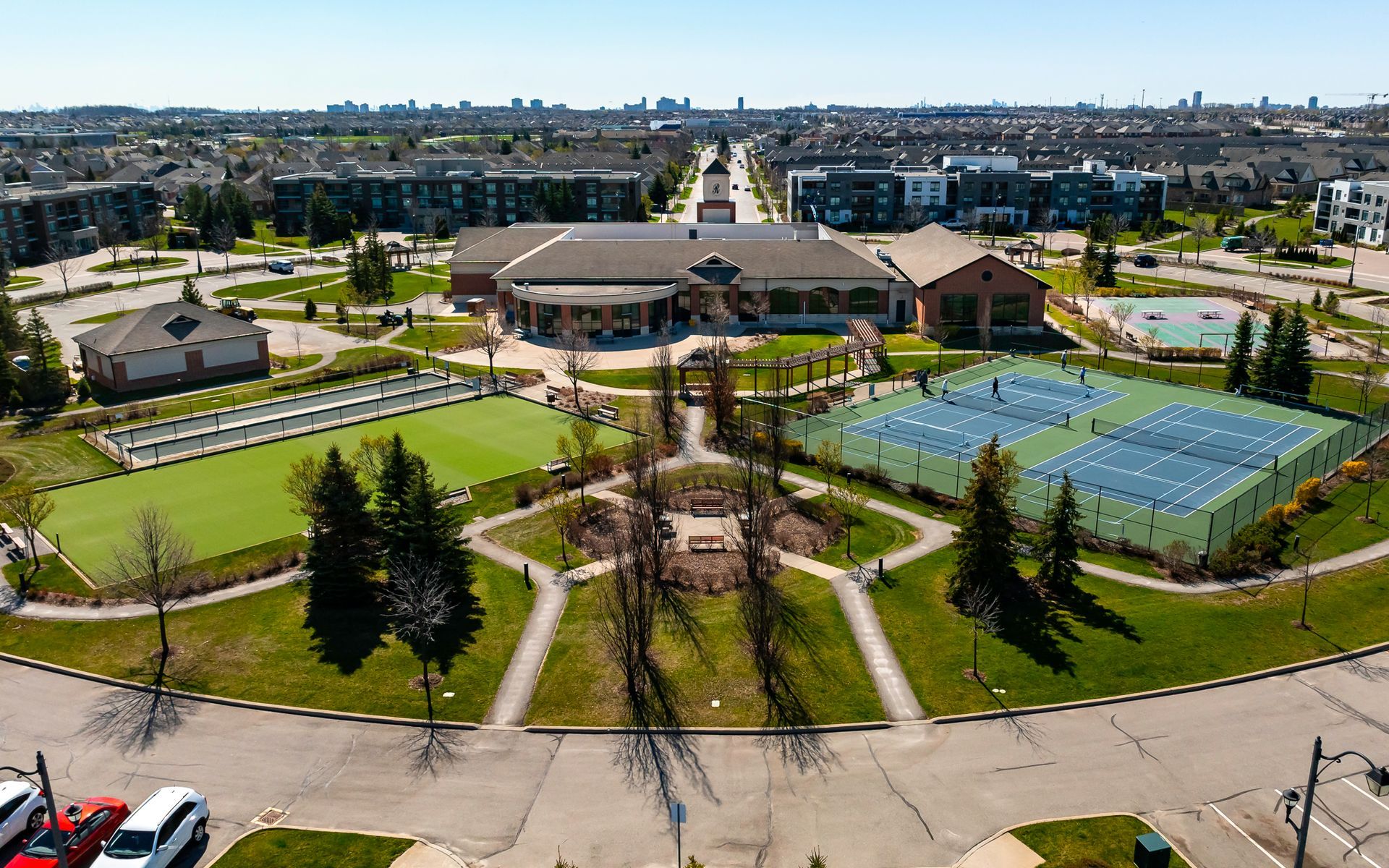 An aerial view of a park with tennis courts and a building in the background.