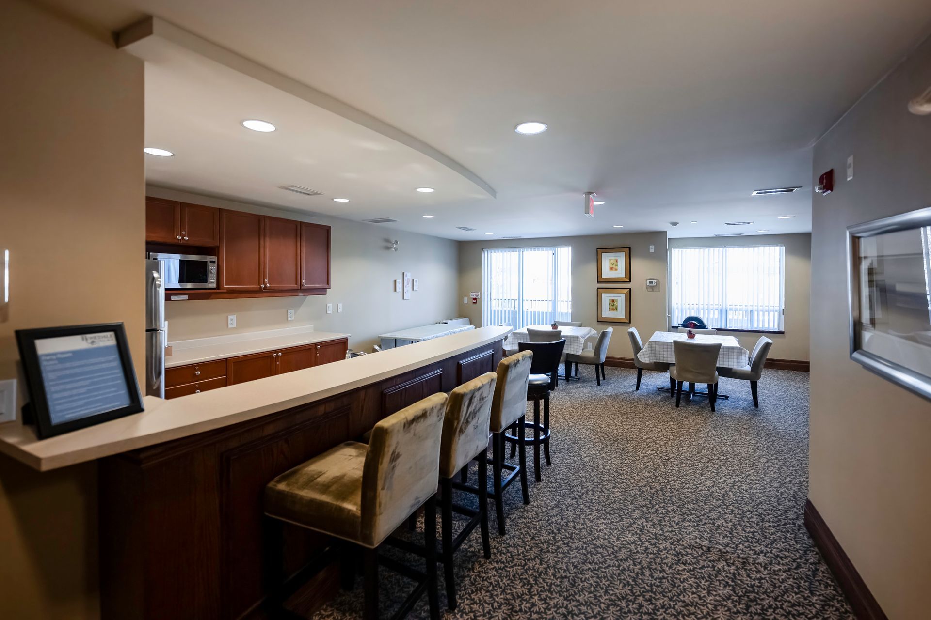 A large room with tables and chairs and a bar