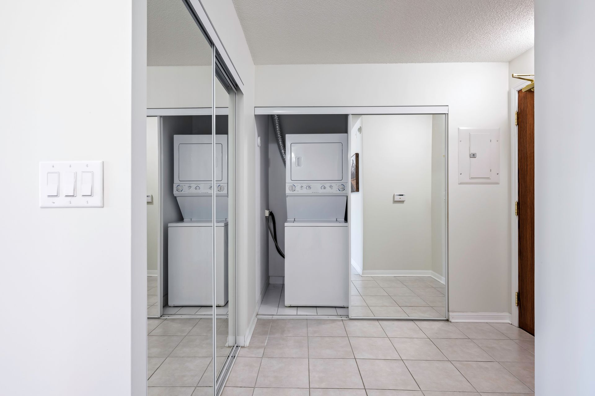 A laundry room with a washer and dryer and a mirror.