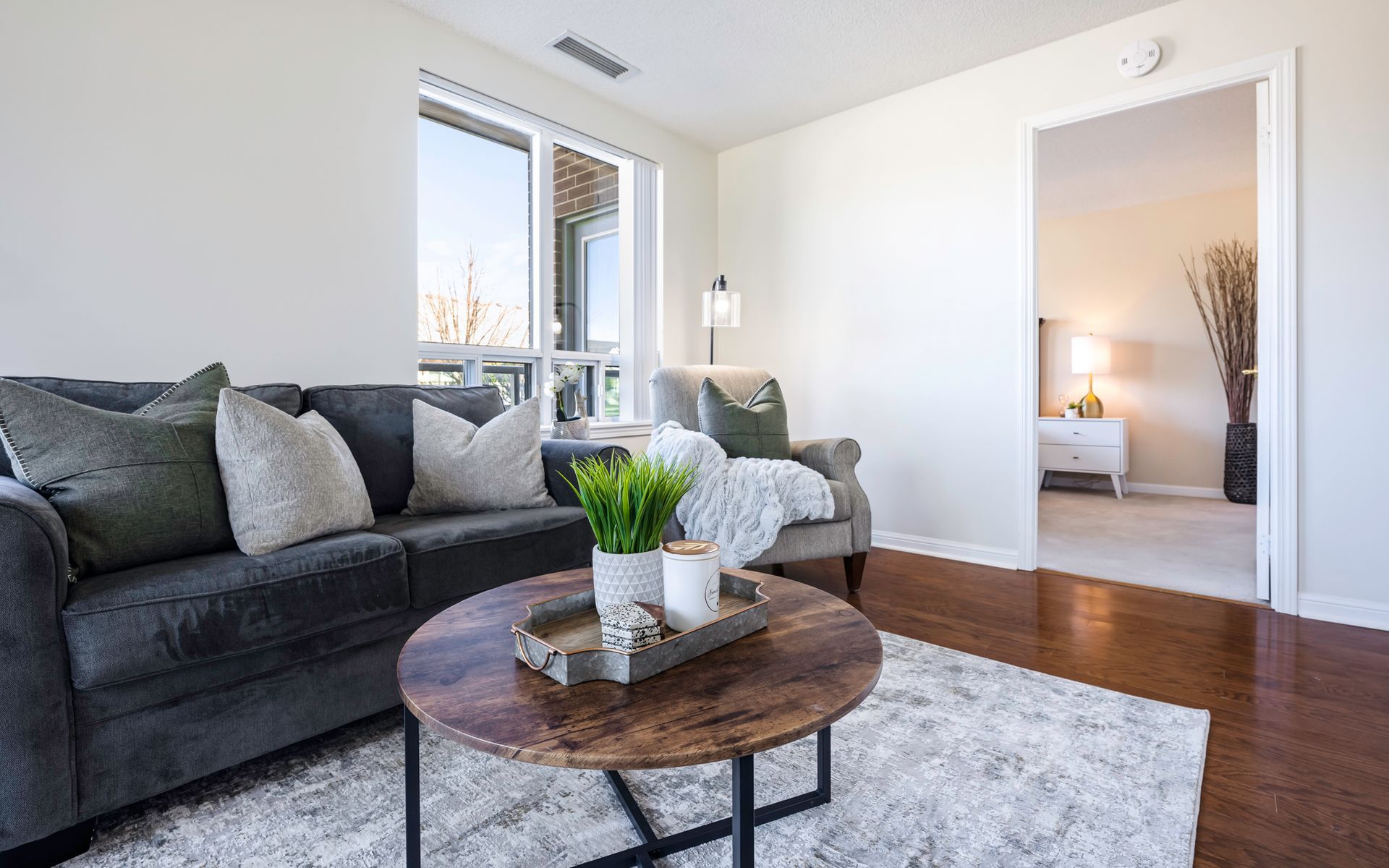 A living room with a couch , chair , coffee table and rug.