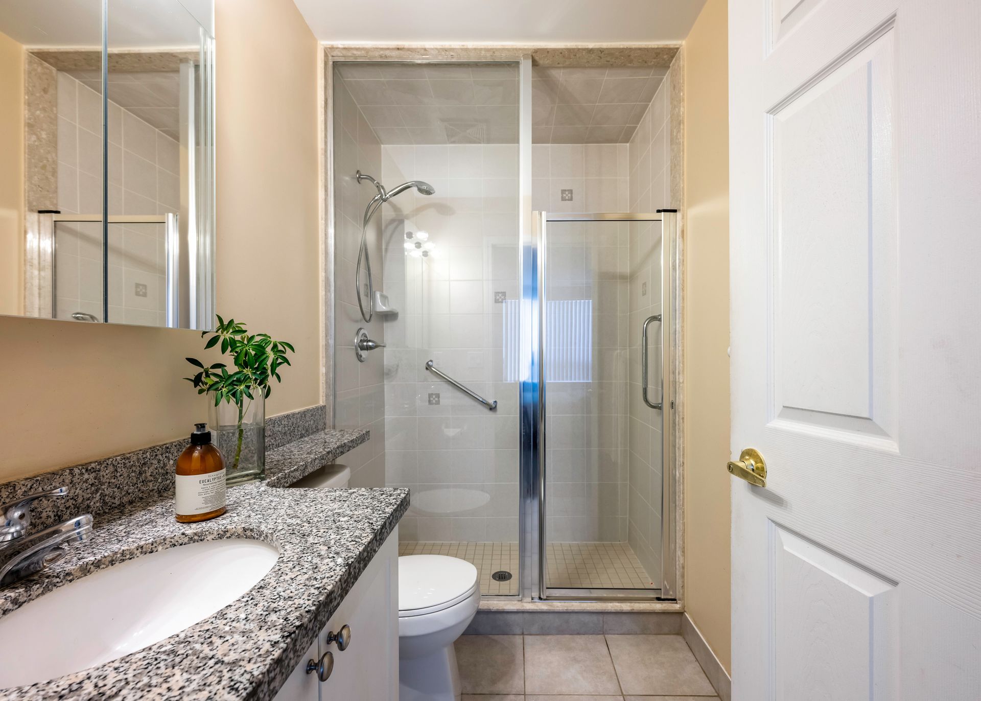 A bathroom with a toilet , sink and shower.