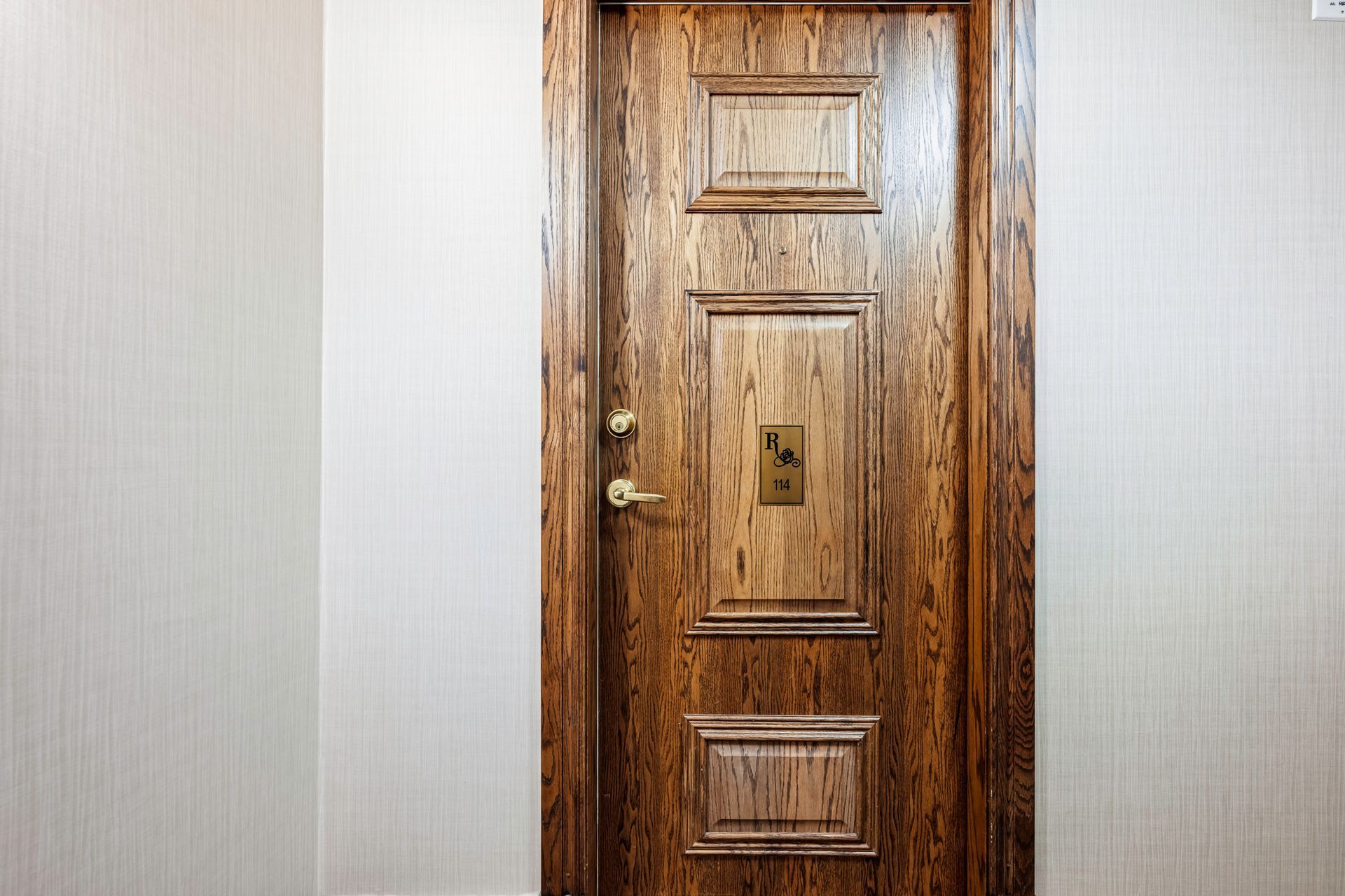 A wooden door is sitting in a hallway next to a wall.