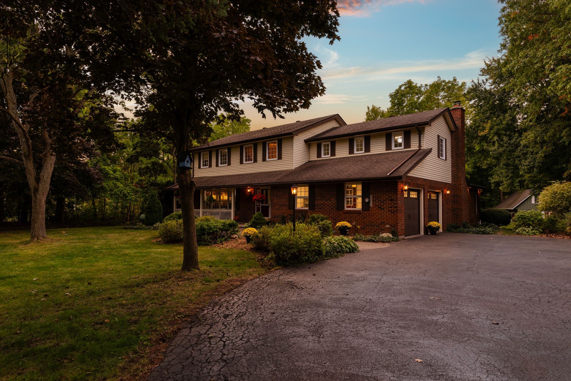 A house with a driveway and trees in front of it