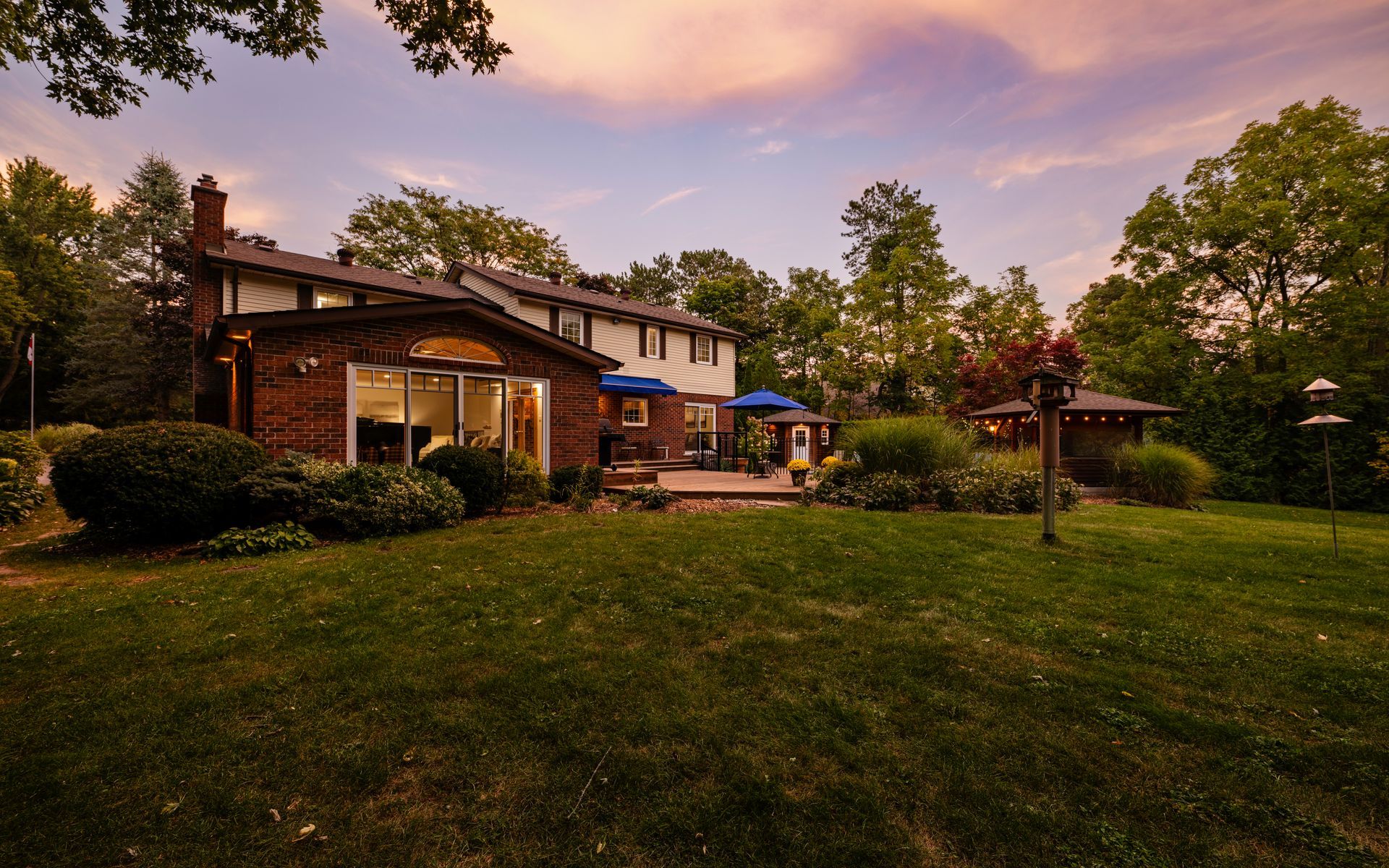 A large brick house with a large lawn in front of it