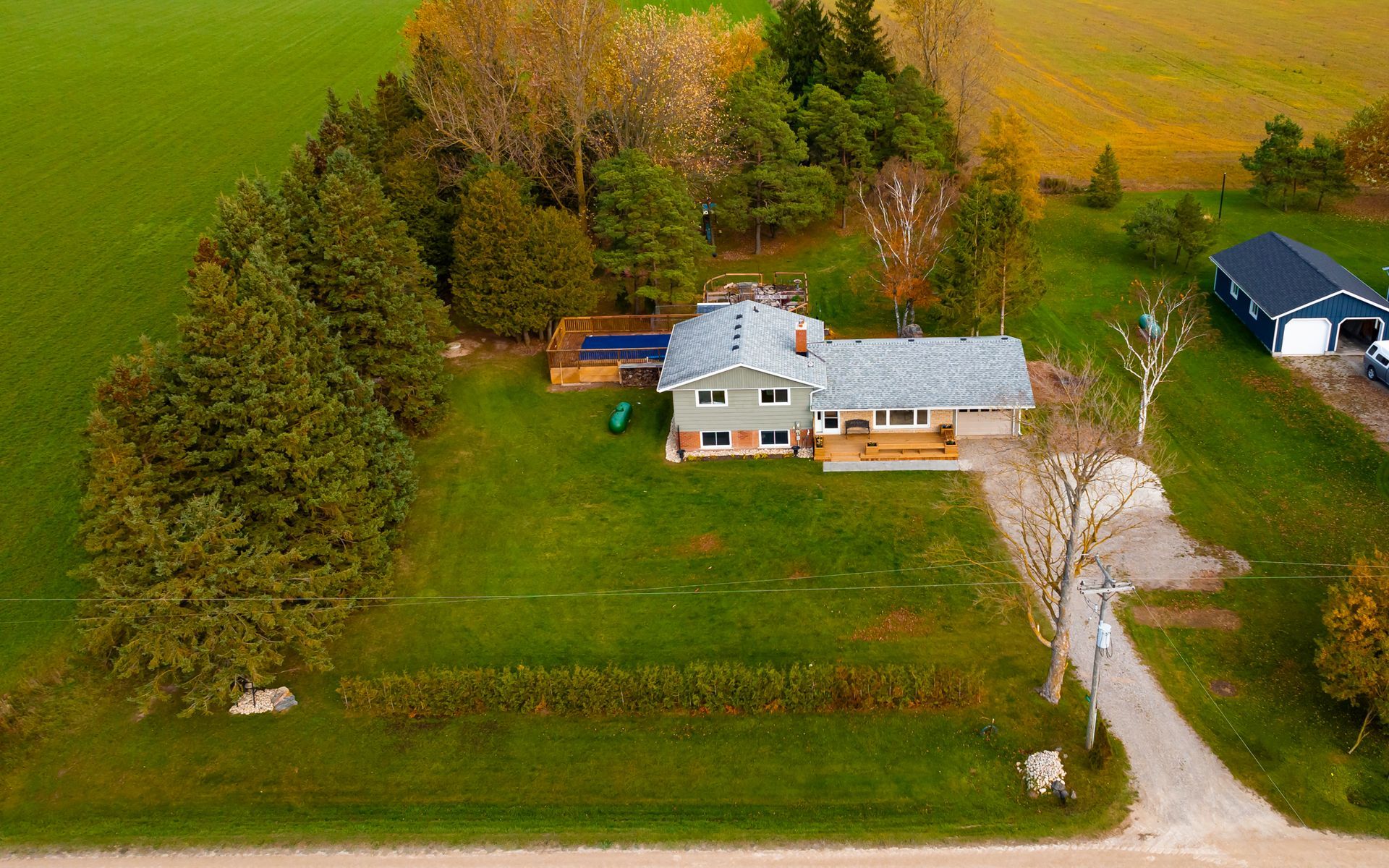 An aerial view of a house in the middle of a grassy field.