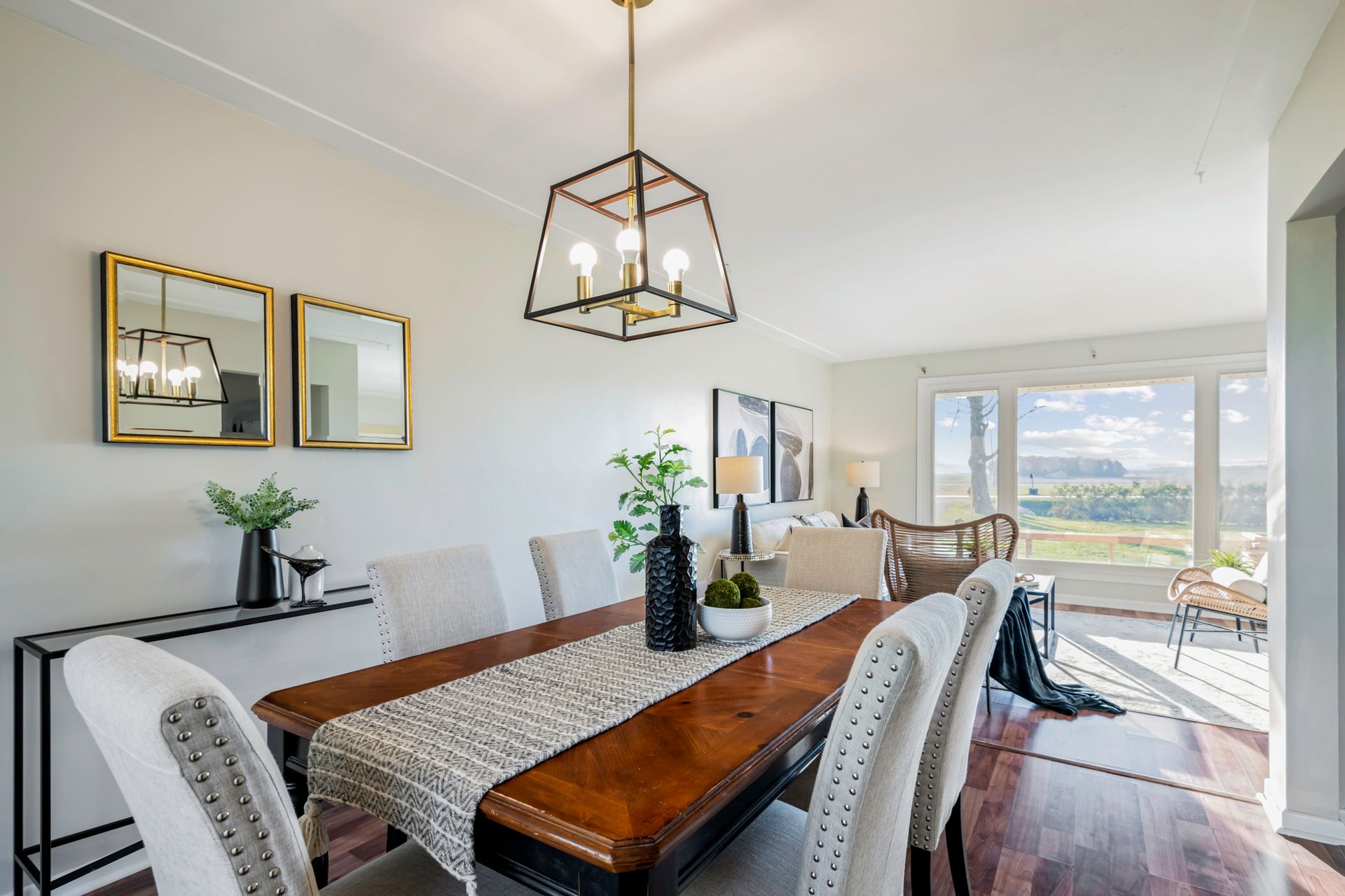 A dining room with a wooden table and chairs and a chandelier.