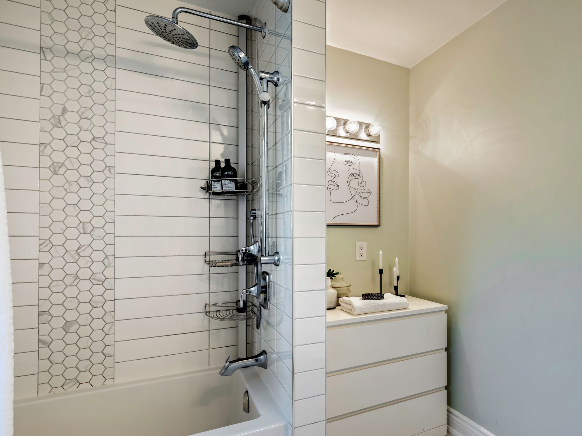 A bathroom with a tub , shower , and dresser.