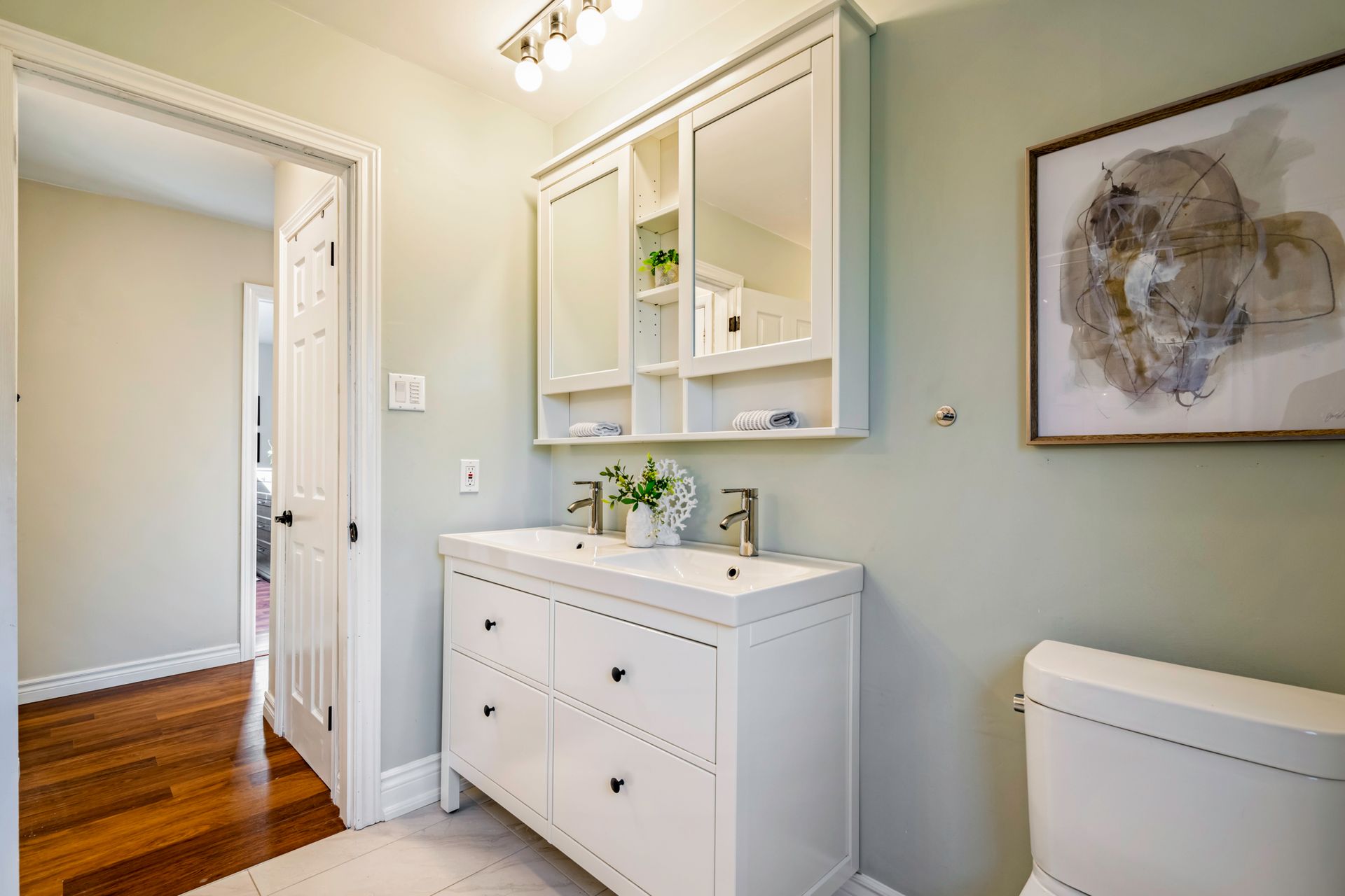 A bathroom with a sink , toilet and mirror.
