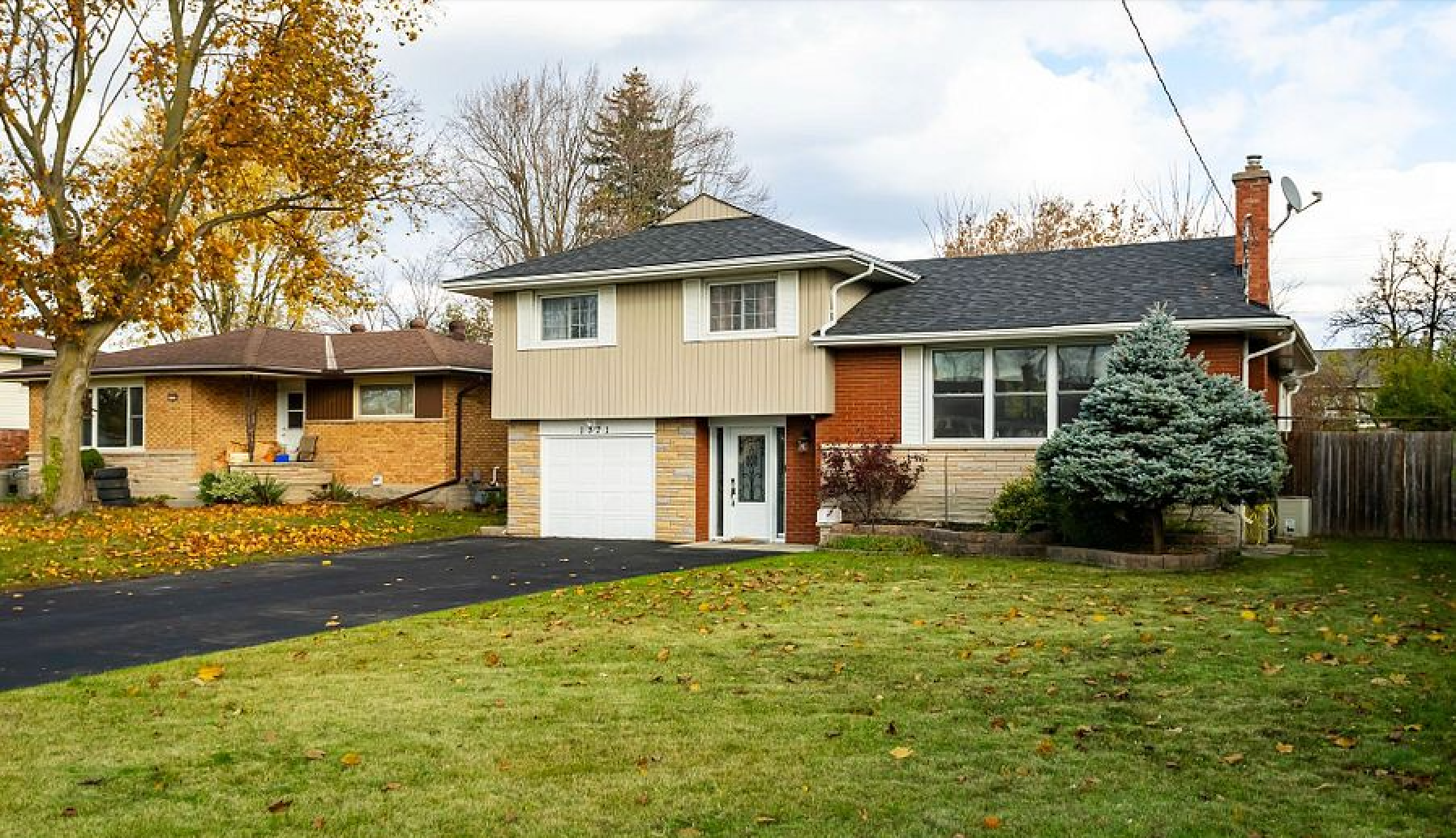 A house with a garage and a driveway in front of it