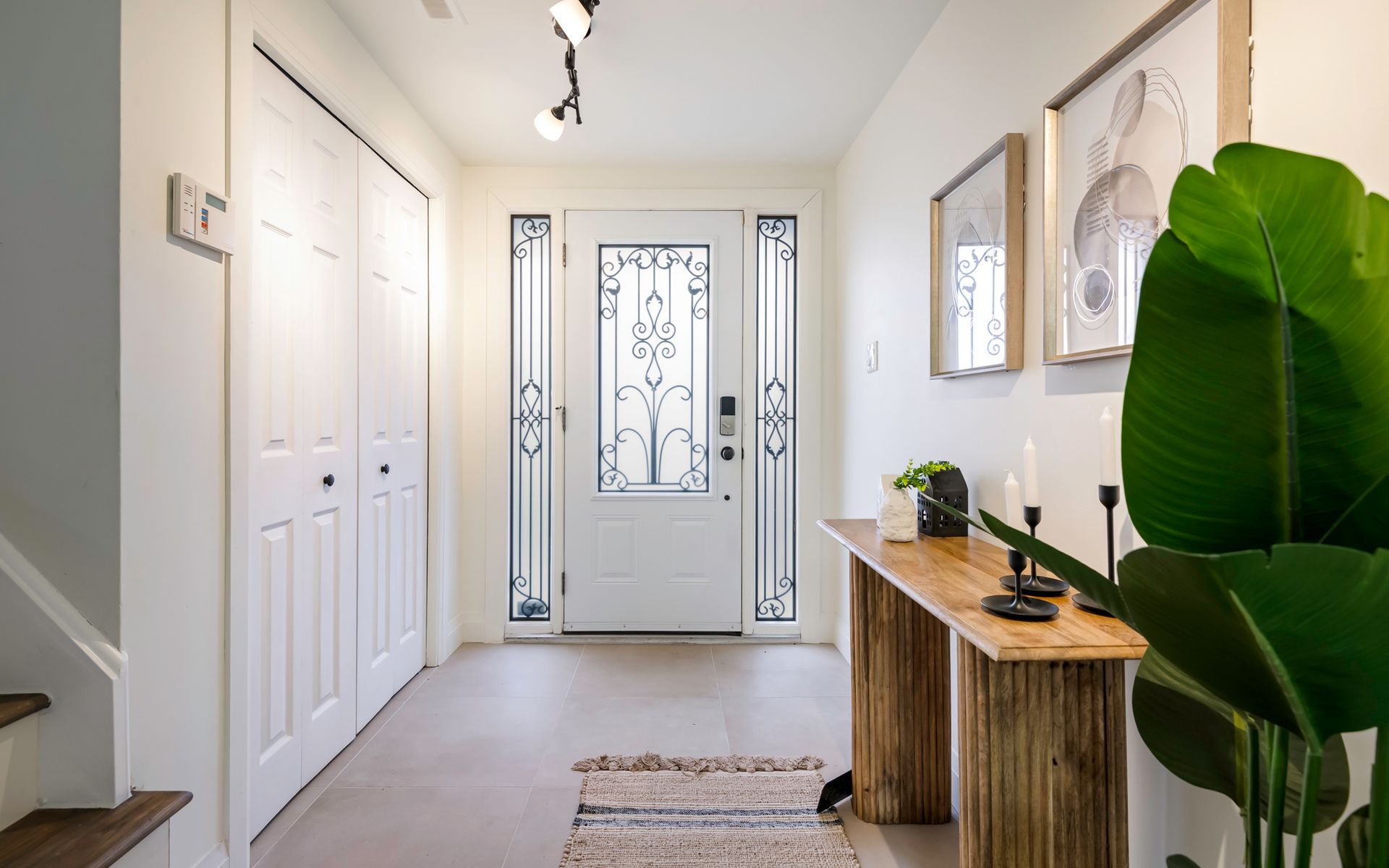 A hallway in a house with a wooden table and a plant.
