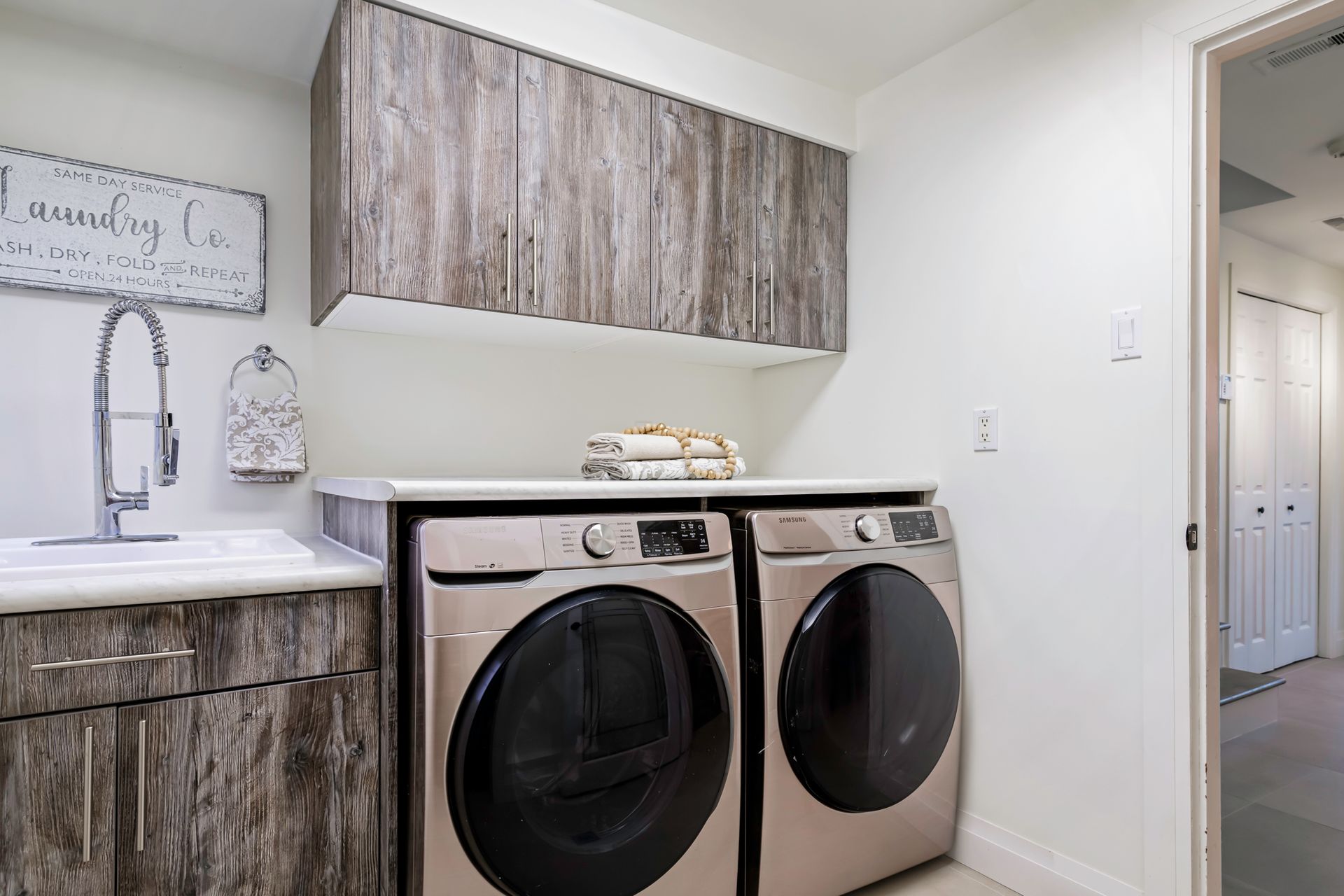 A laundry room with a washer and dryer and a sink.