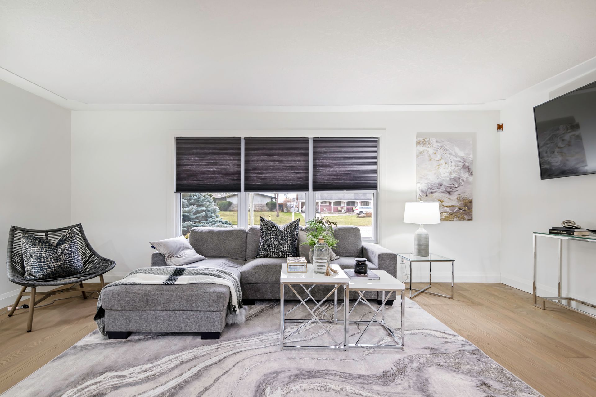 A living room with a couch , chair , table , rug and television.