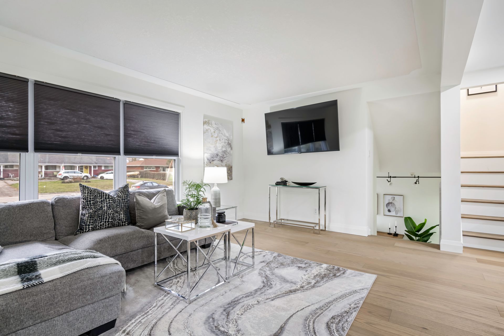 A living room with a couch and a television on the wall.