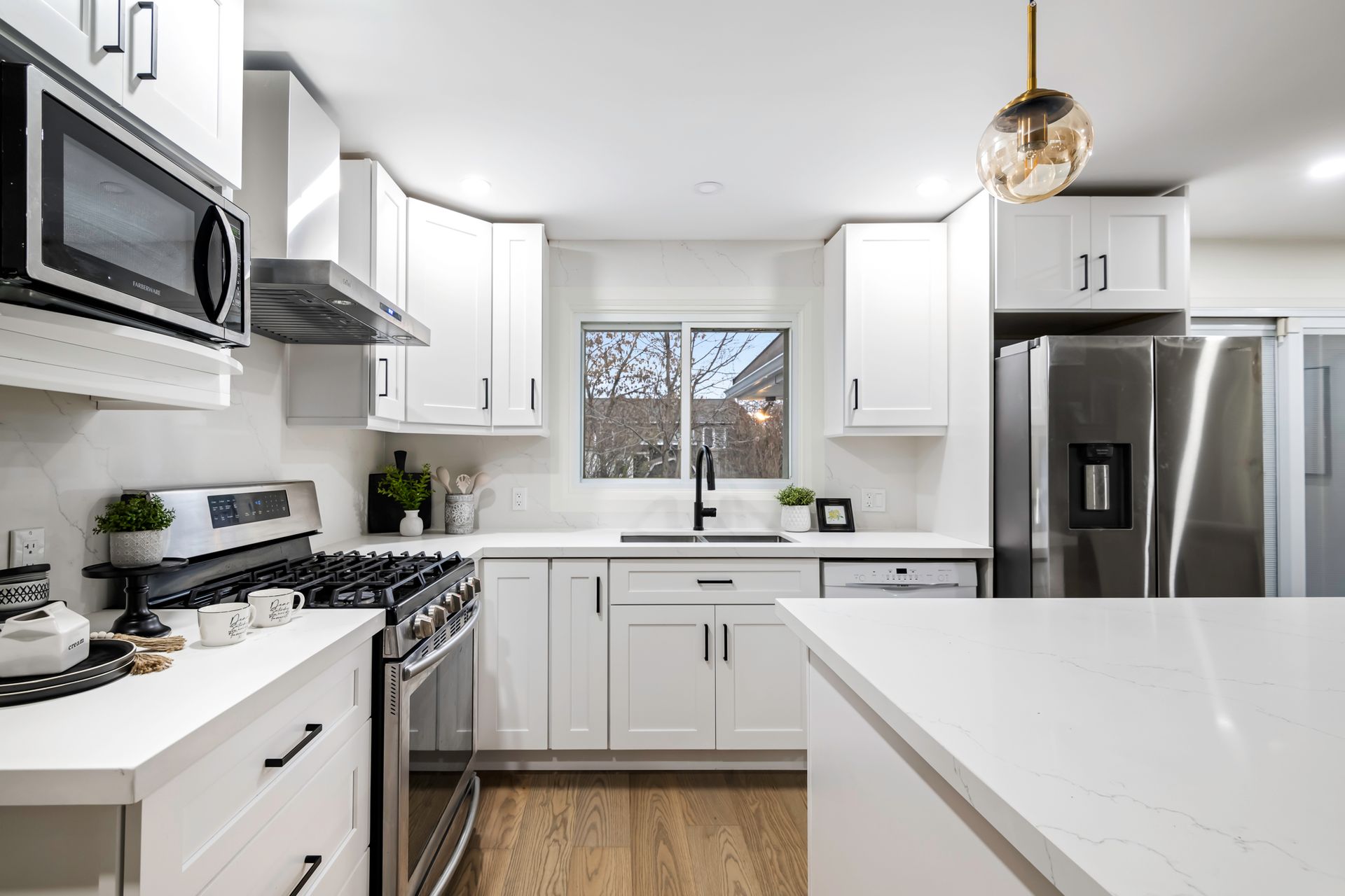 A kitchen with white cabinets and stainless steel appliances.