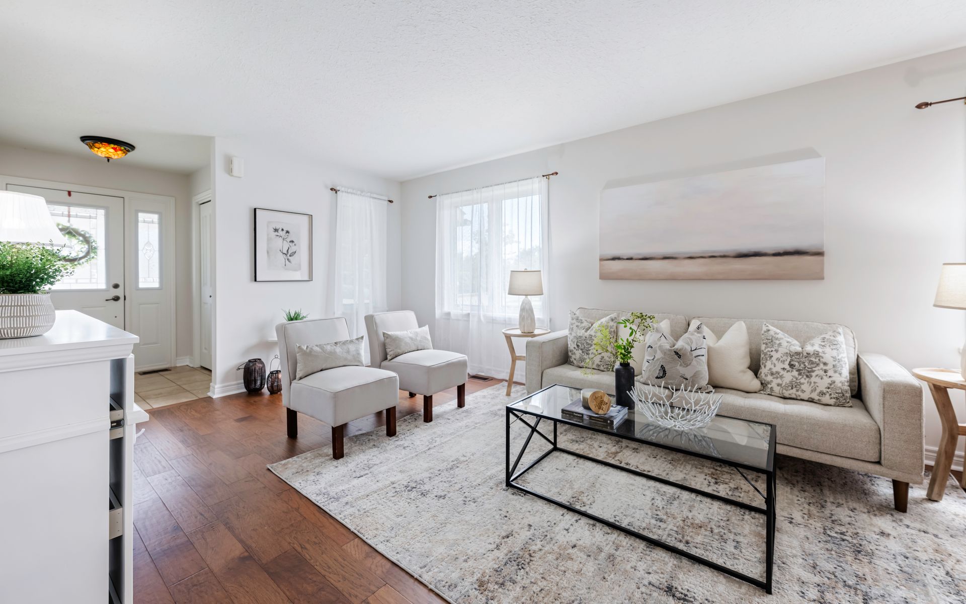 A living room with a couch , chairs , and a coffee table.