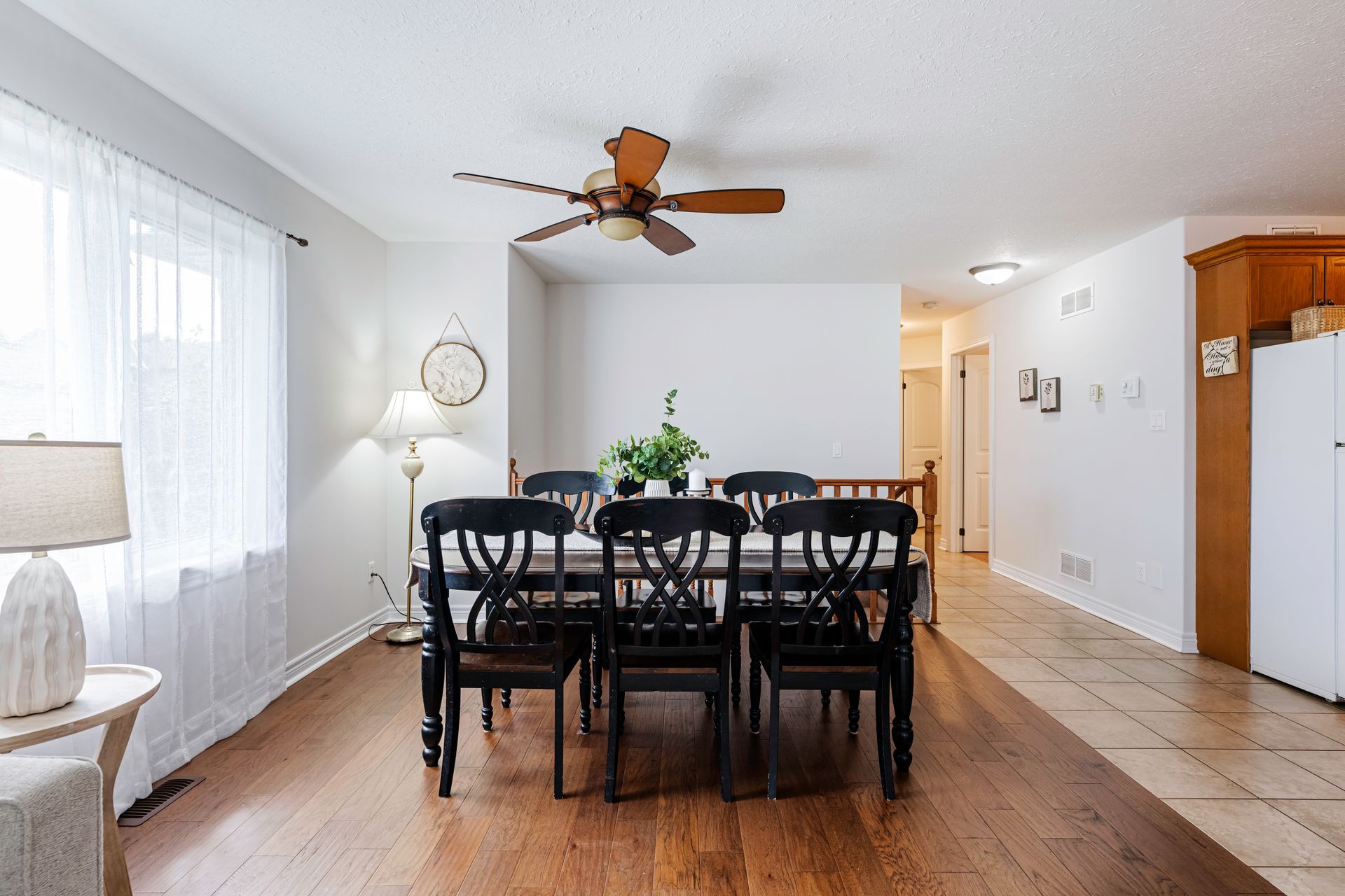 A dining room with a table and chairs and a ceiling fan