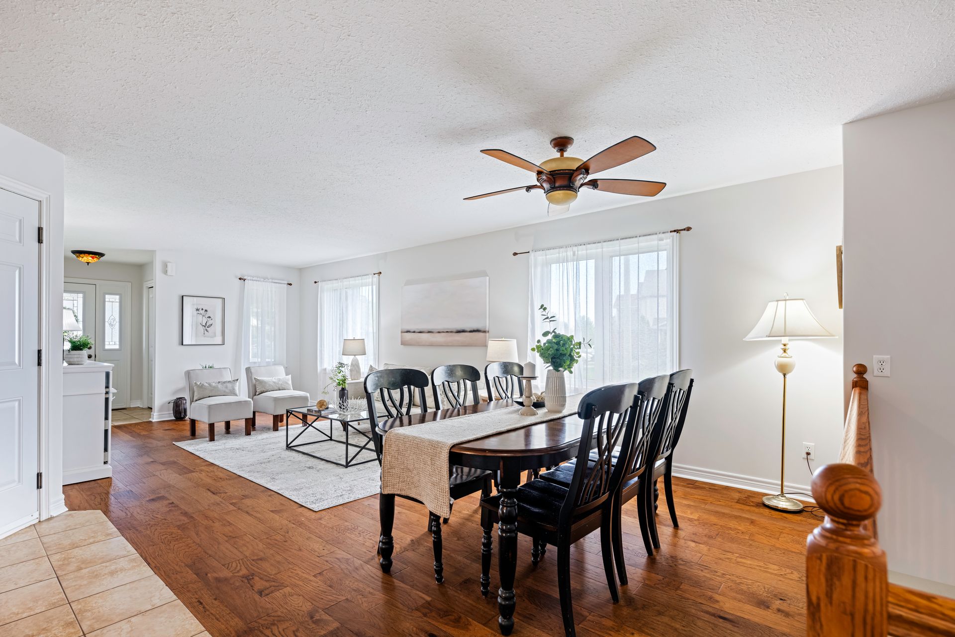 A dining room with a table and chairs and a ceiling fan.