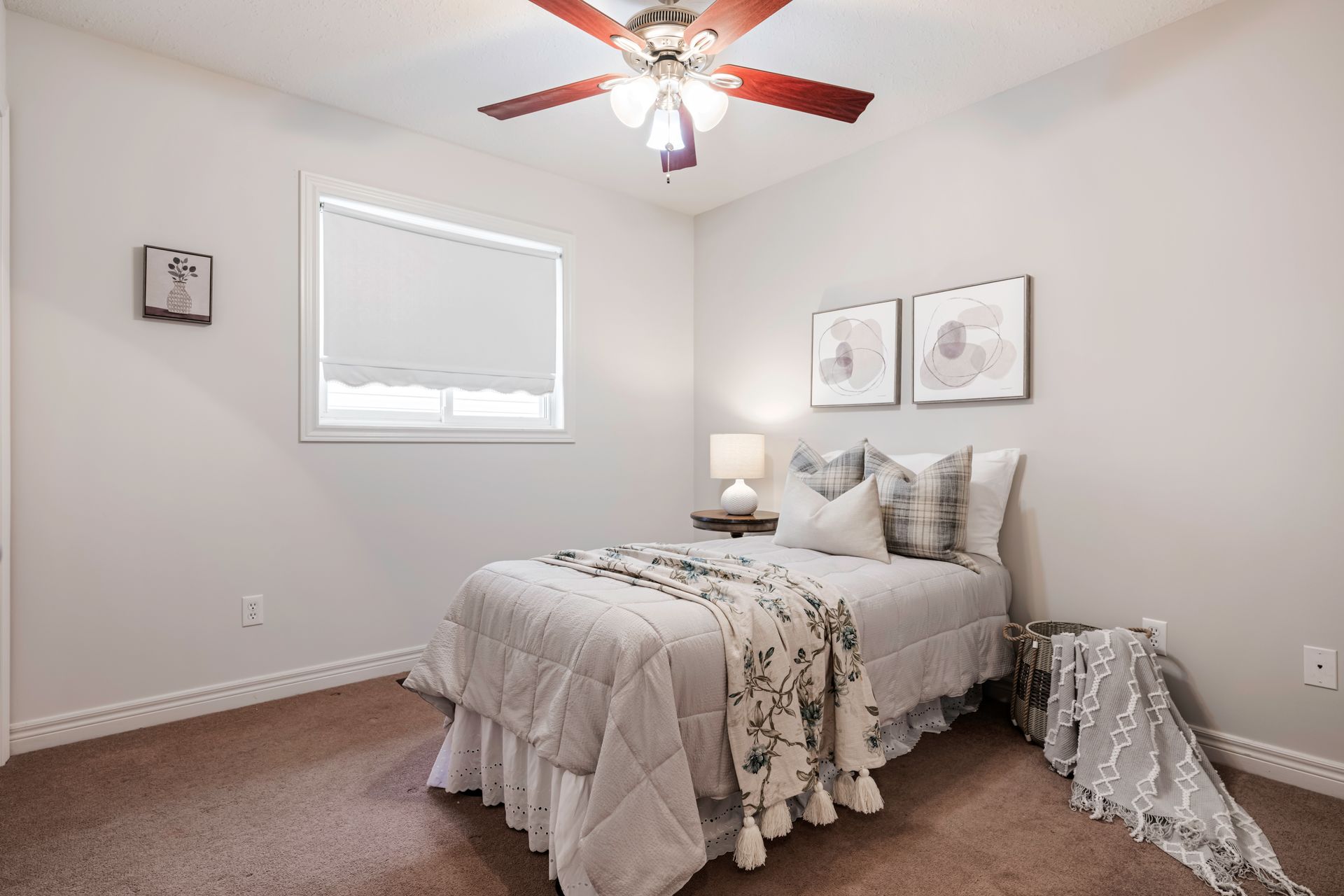 A bedroom with a bed and a ceiling fan.