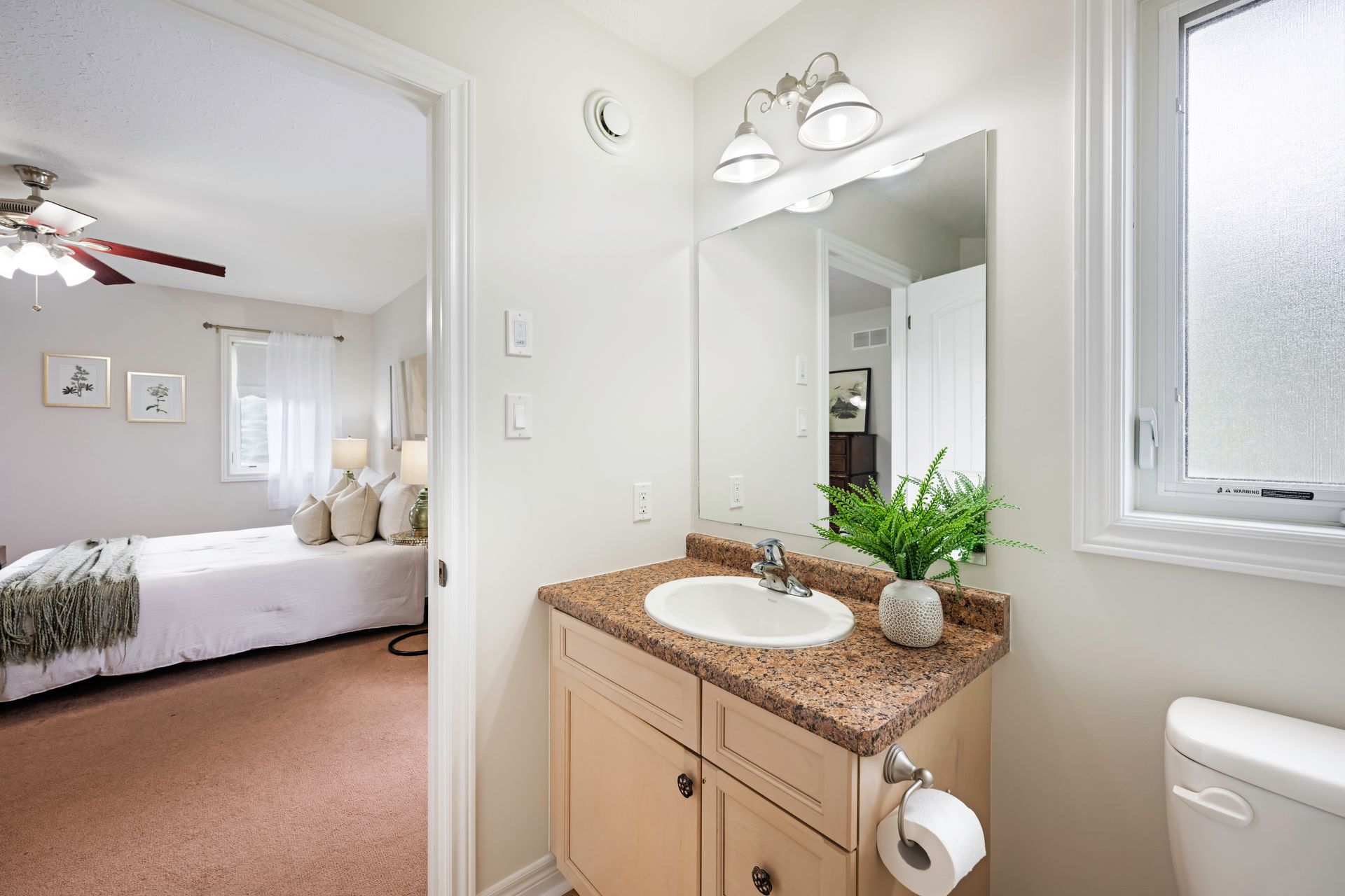 A bathroom with a sink , toilet and mirror.