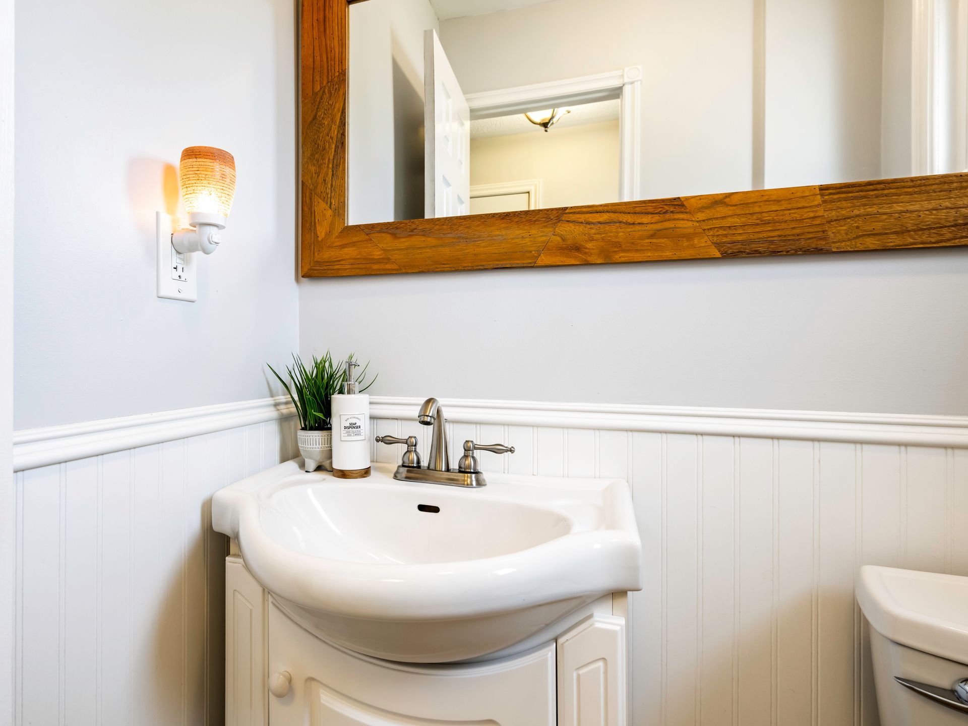 A bathroom with a sink , toilet and mirror.