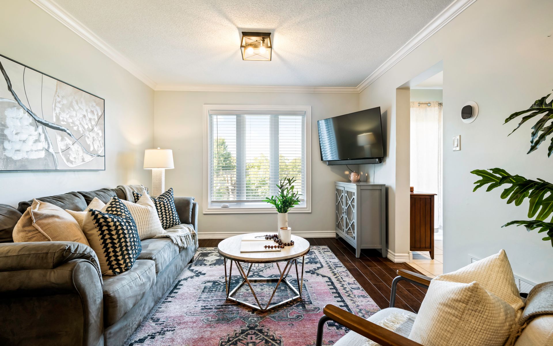 A living room with a couch , chair , coffee table and television.