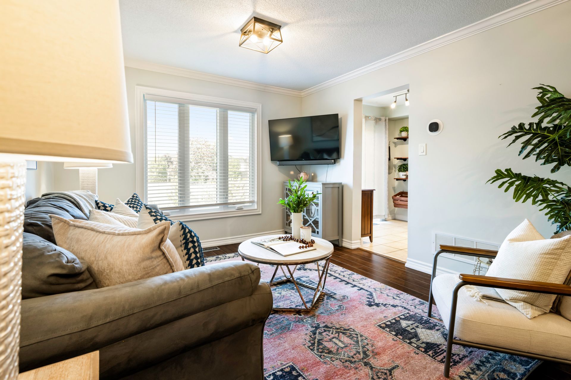 A living room with a couch , chair , table and television.