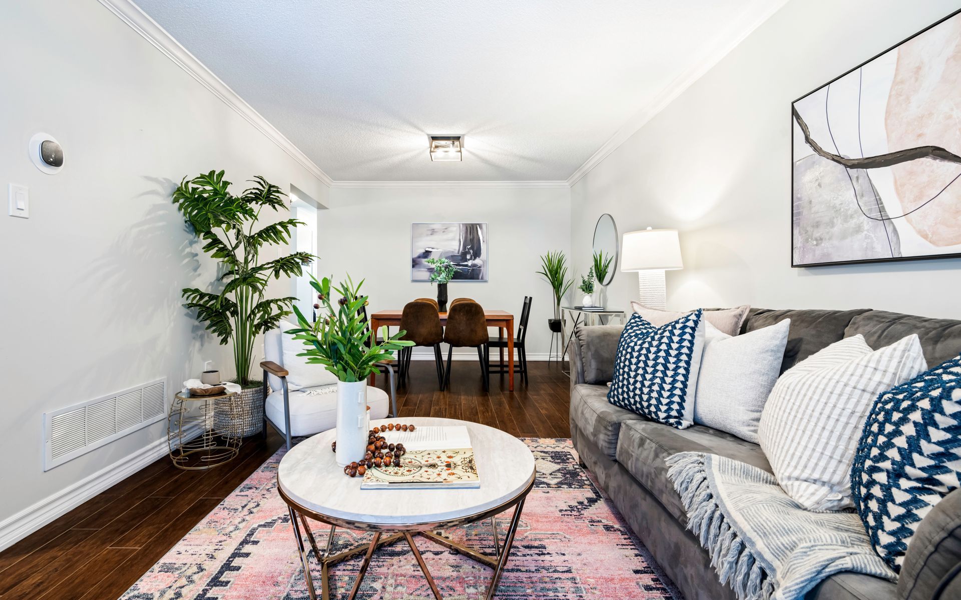 A living room with a couch , coffee table and dining room in the background.