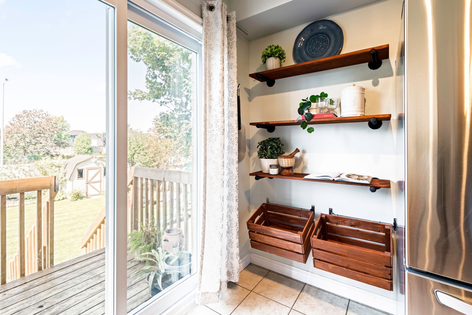 A kitchen with sliding glass doors , wooden shelves , and a stainless steel refrigerator.