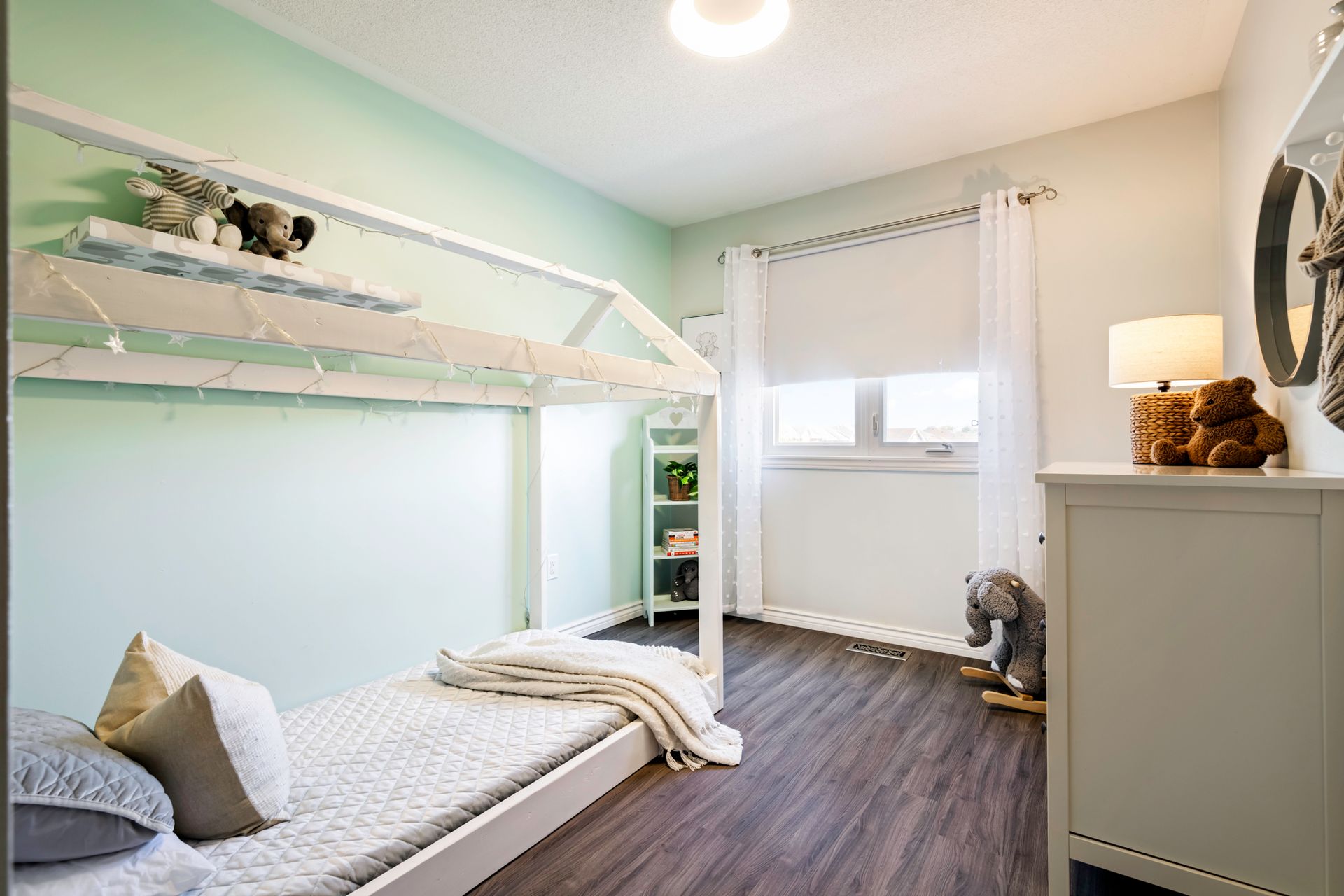 A bedroom with a bunk bed and a dresser.