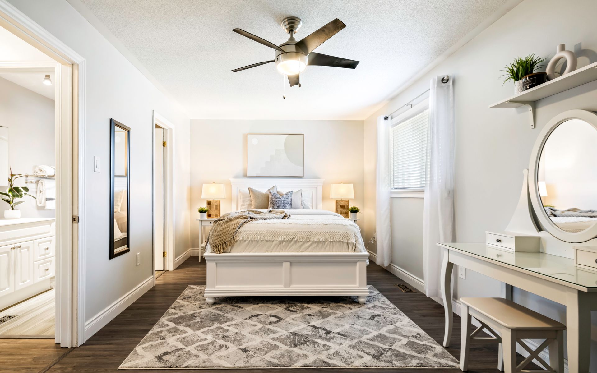 A bedroom with a bed , dresser , mirror and ceiling fan.