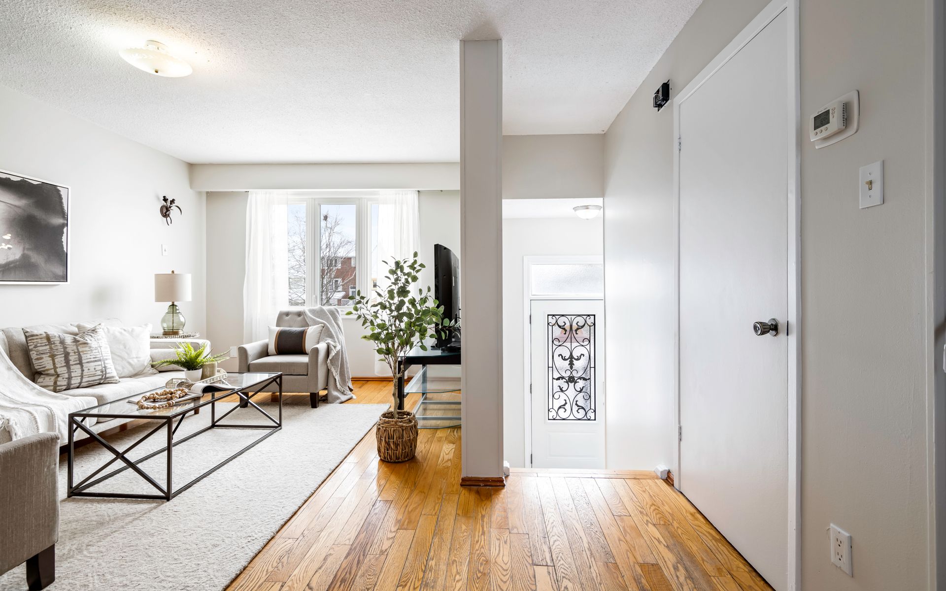 A living room with hardwood floors and a couch and chairs.