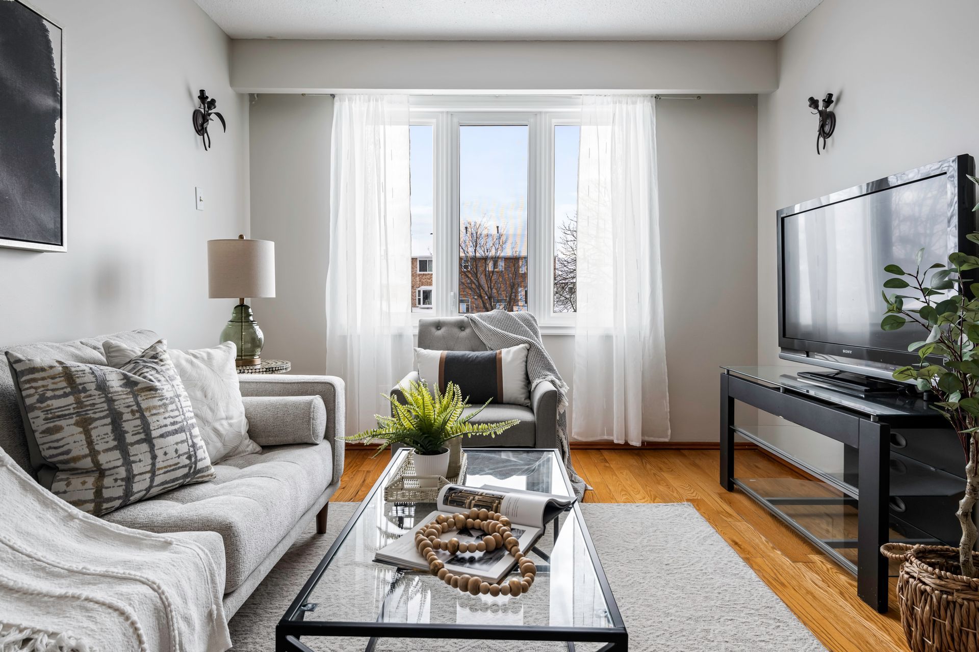 A living room with a couch , chair , coffee table and television.