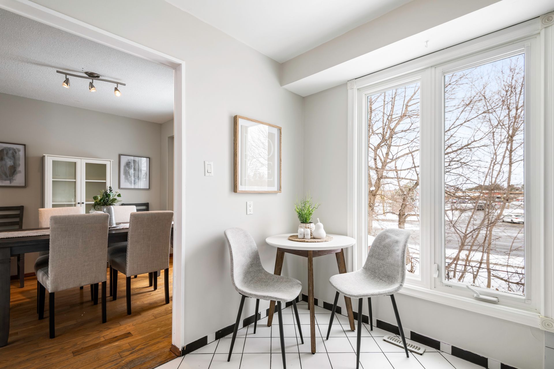 A dining room with a table and chairs and a large window.