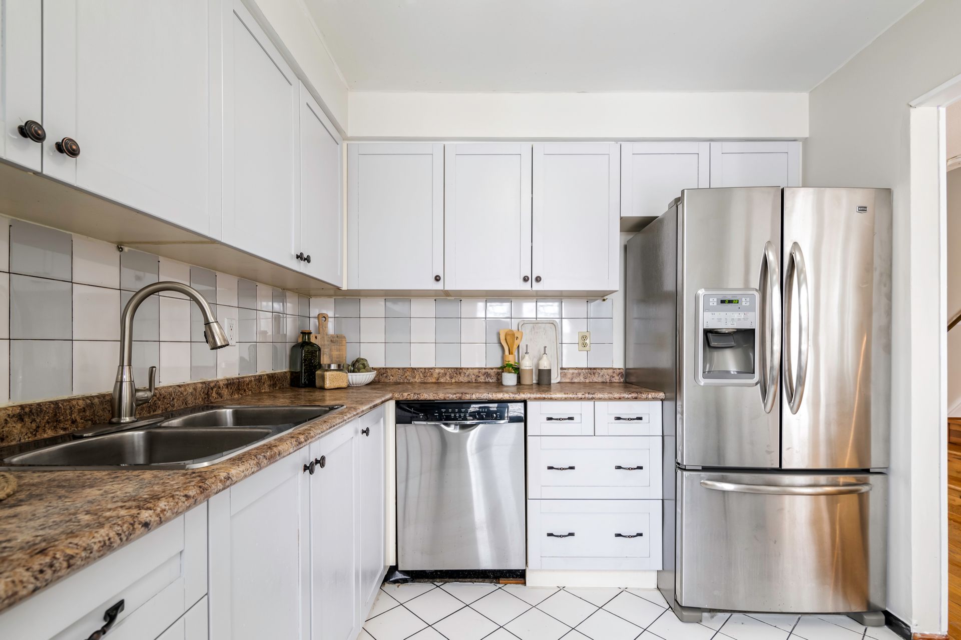 A kitchen with stainless steel appliances and white cabinets