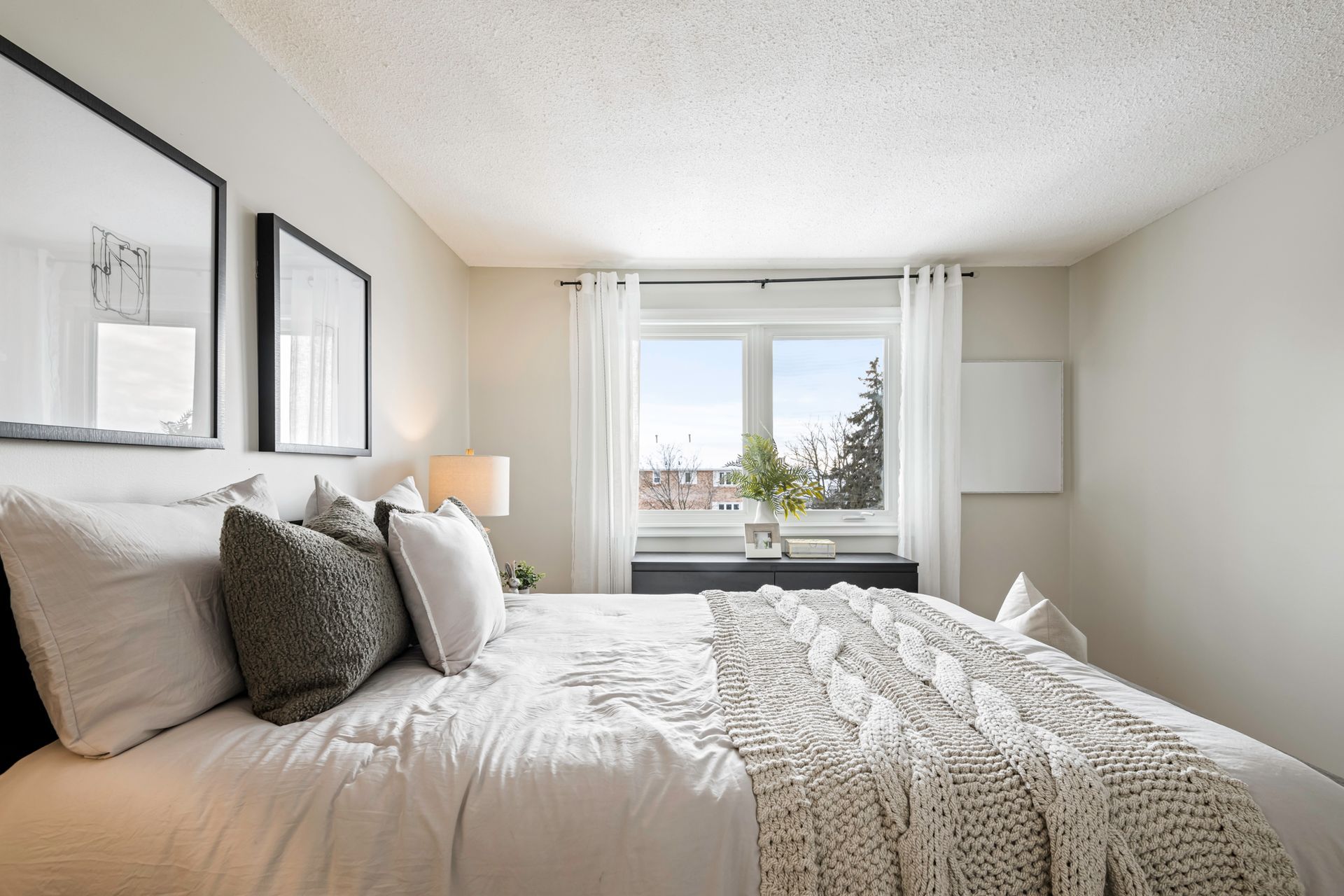 A bedroom with a large bed and a window.