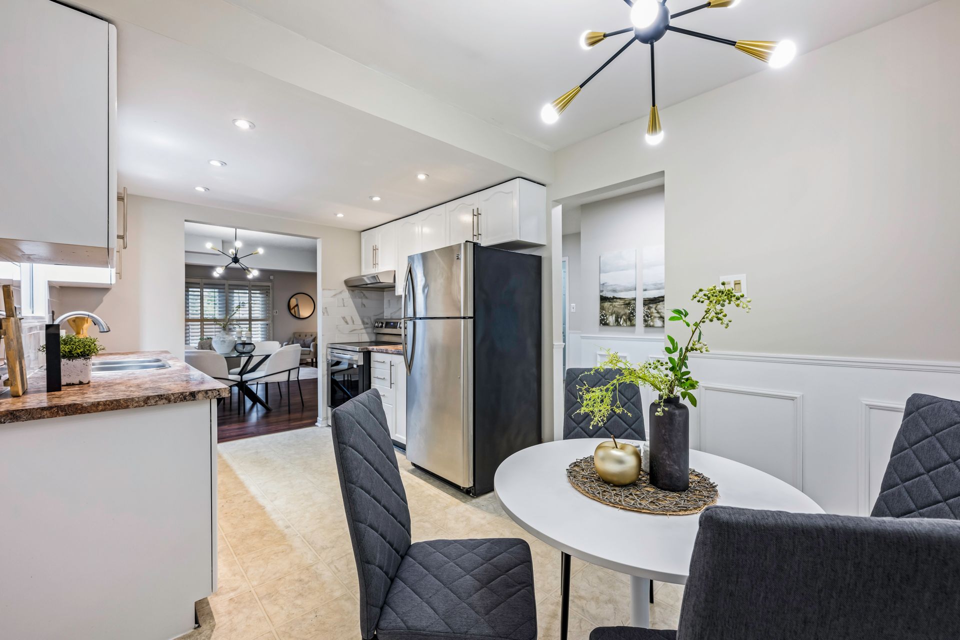 A kitchen with a table and chairs and a refrigerator.