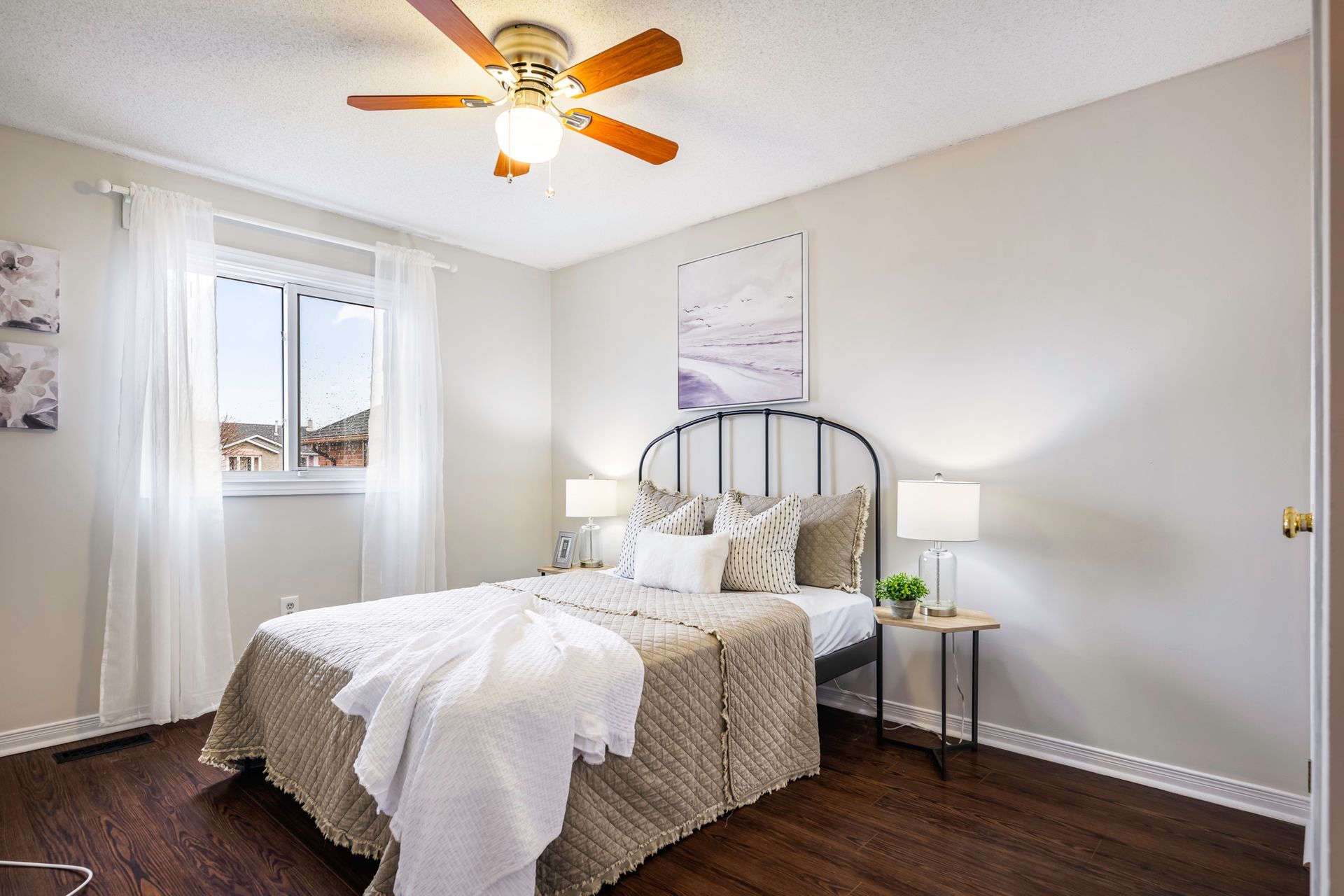 A bedroom with a bed and a ceiling fan.