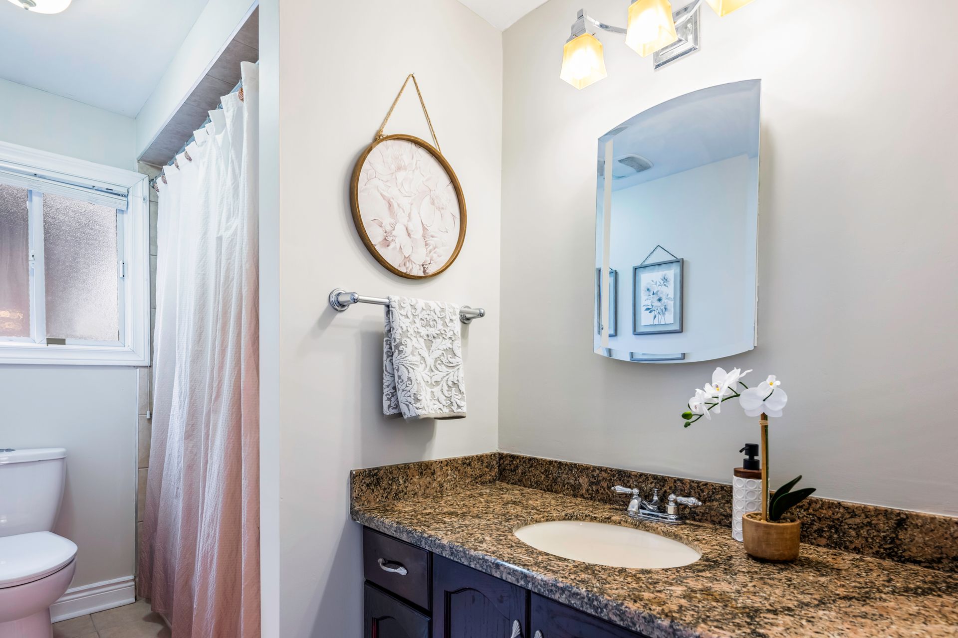 A bathroom with a sink , toilet , and mirror.