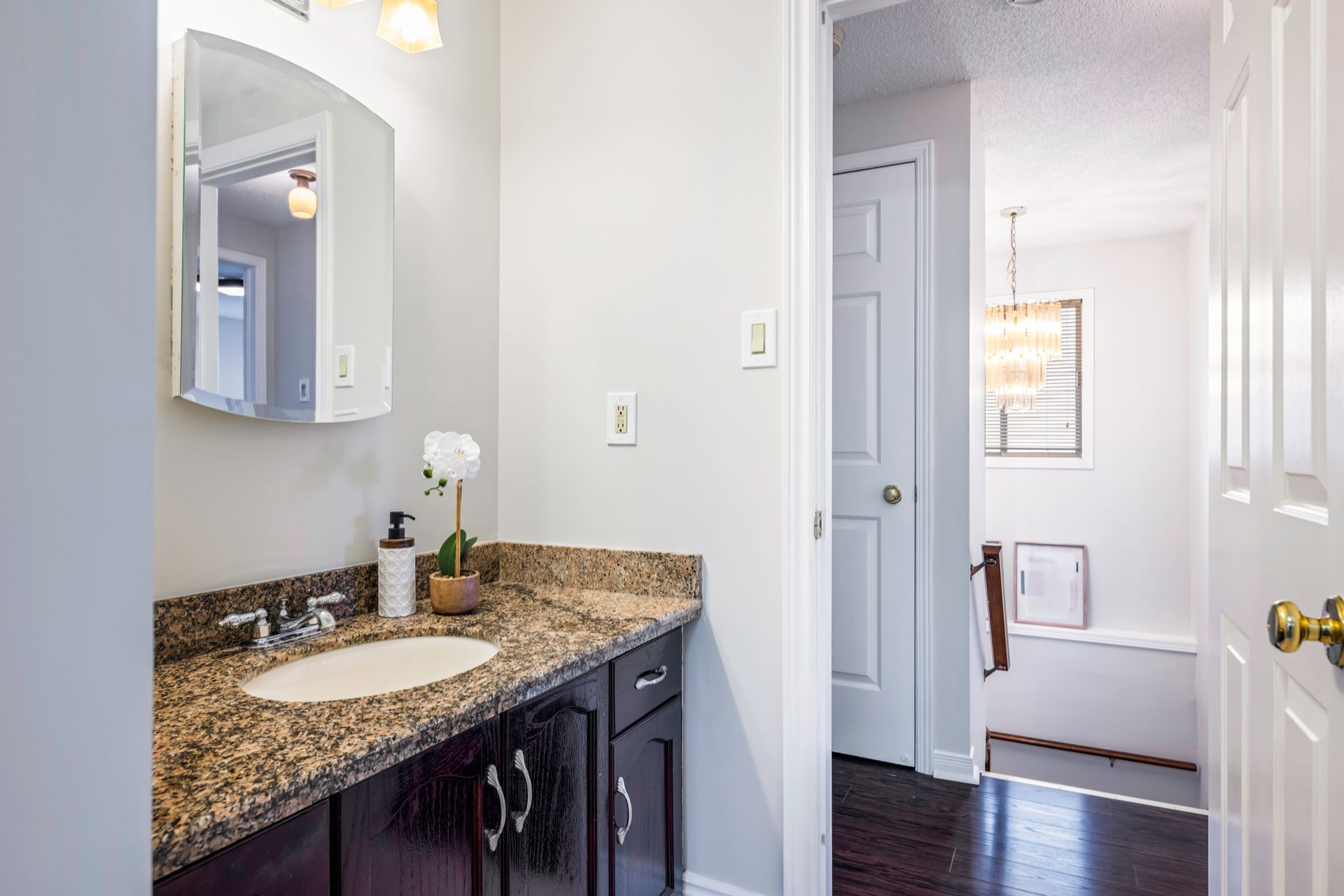 A bathroom with a sink , mirror and cabinets.